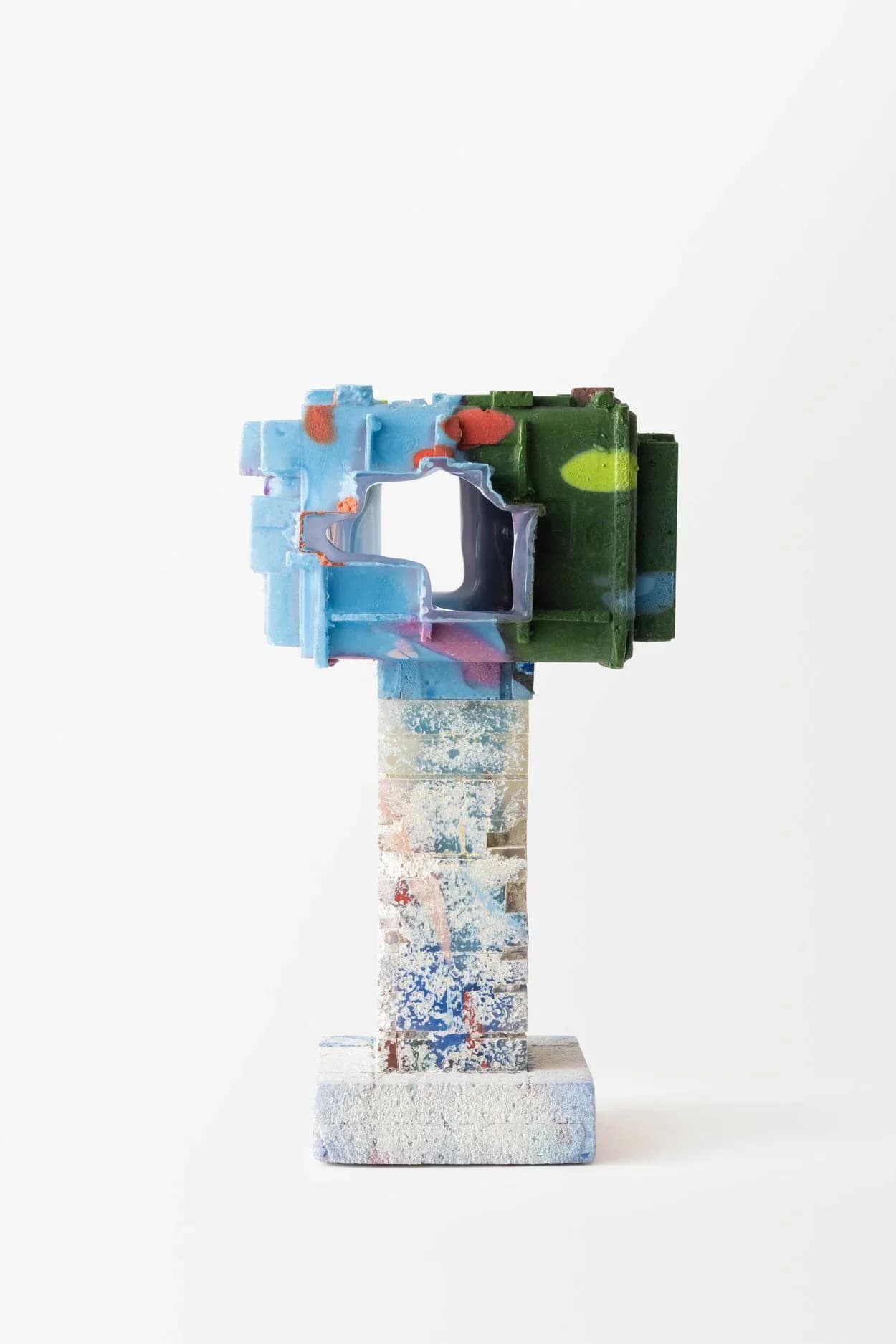 Sculptural architectural model featuring stacked geometric forms in blue, green, and black with a textured concrete base, by Thaddeus Wolfe.