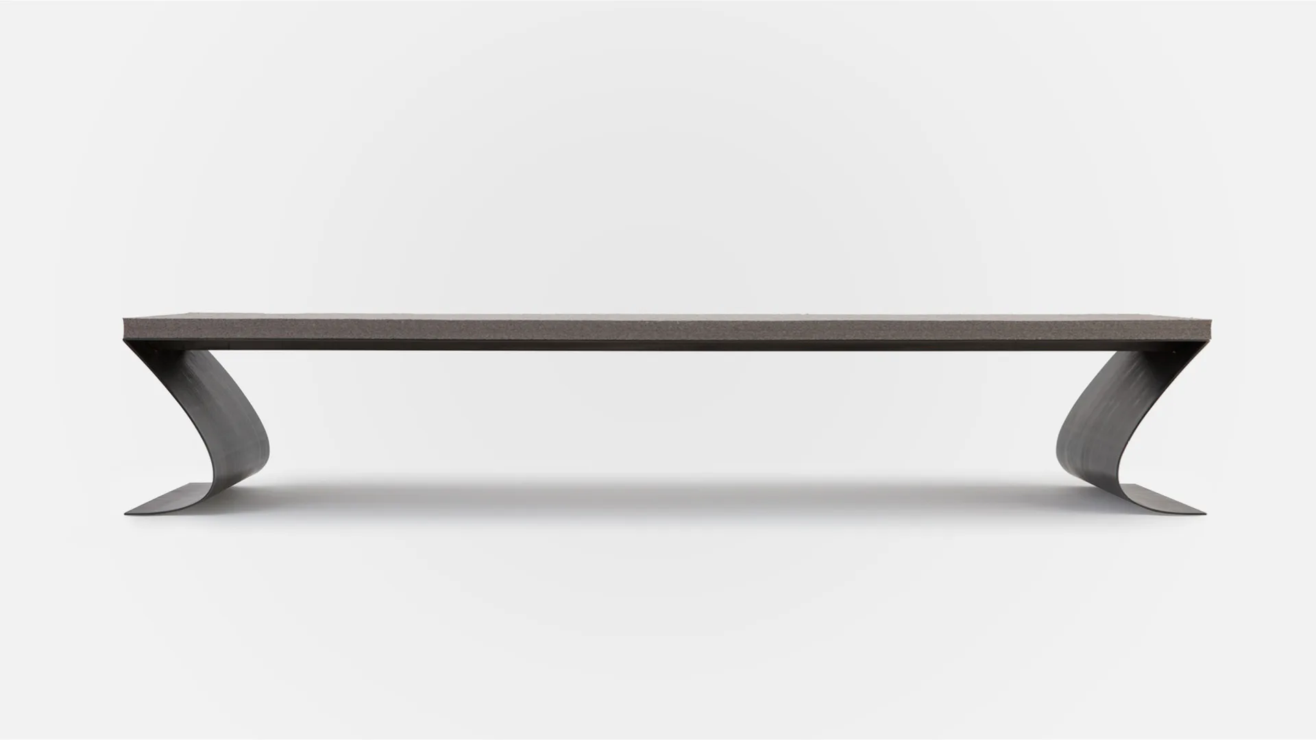 A sleek dark metal shelf or floating console with curved angular supports on each end, shown in profile against a neutral background by Thea von Geldern.