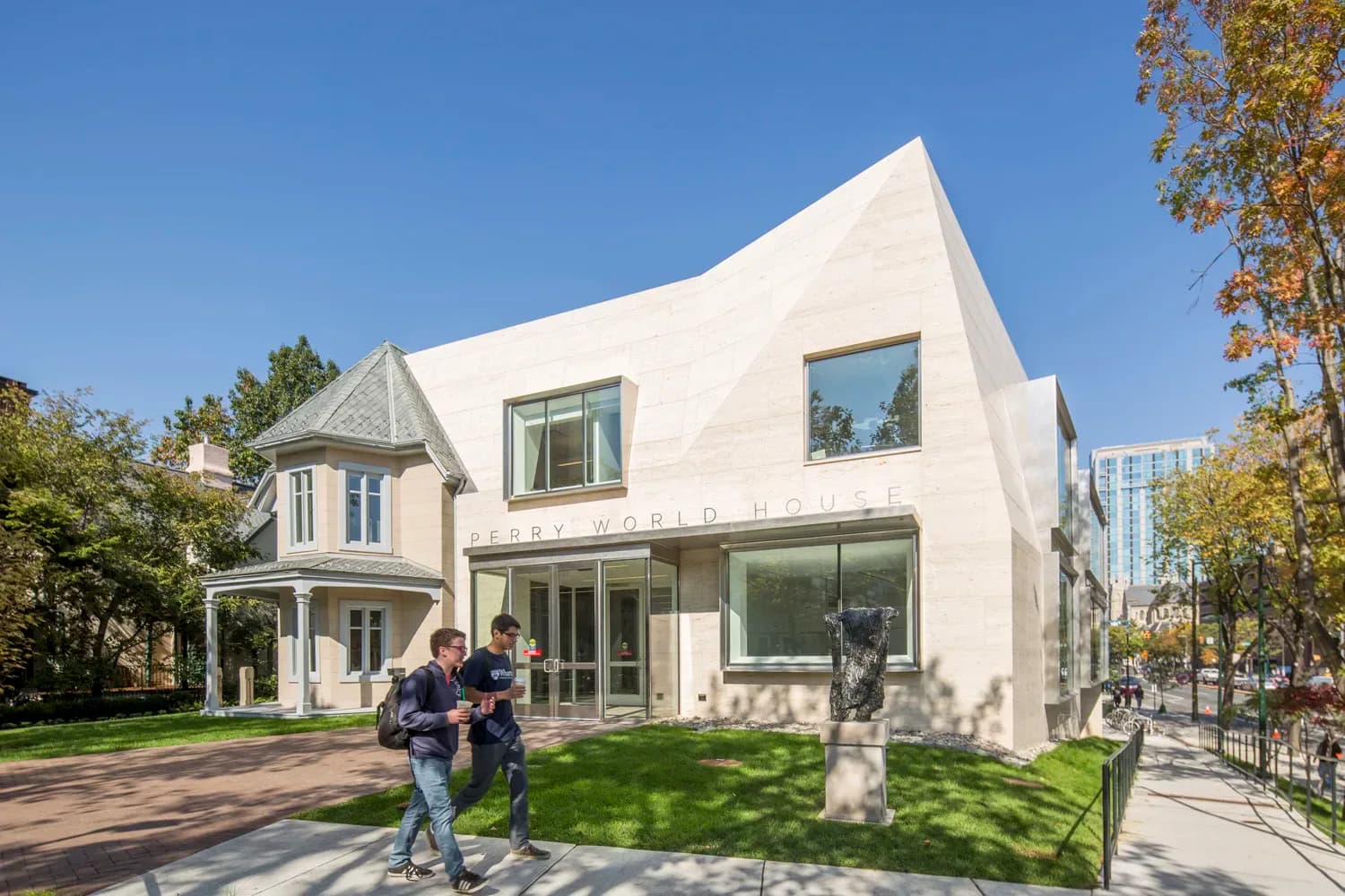 Modern white residential home with curved roofline, large glass windows, and manicured lawn designed by Trevor Wood.