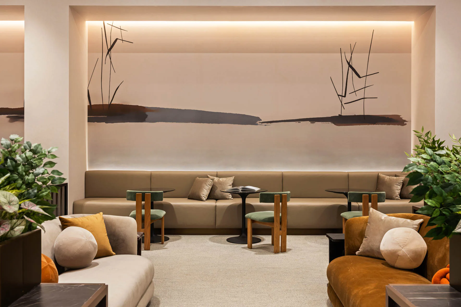 Modern lounge interior with beige seating, wooden side tables, potted plants, and an illuminated wall installation featuring abstract linear art by Tugce Kodalak.