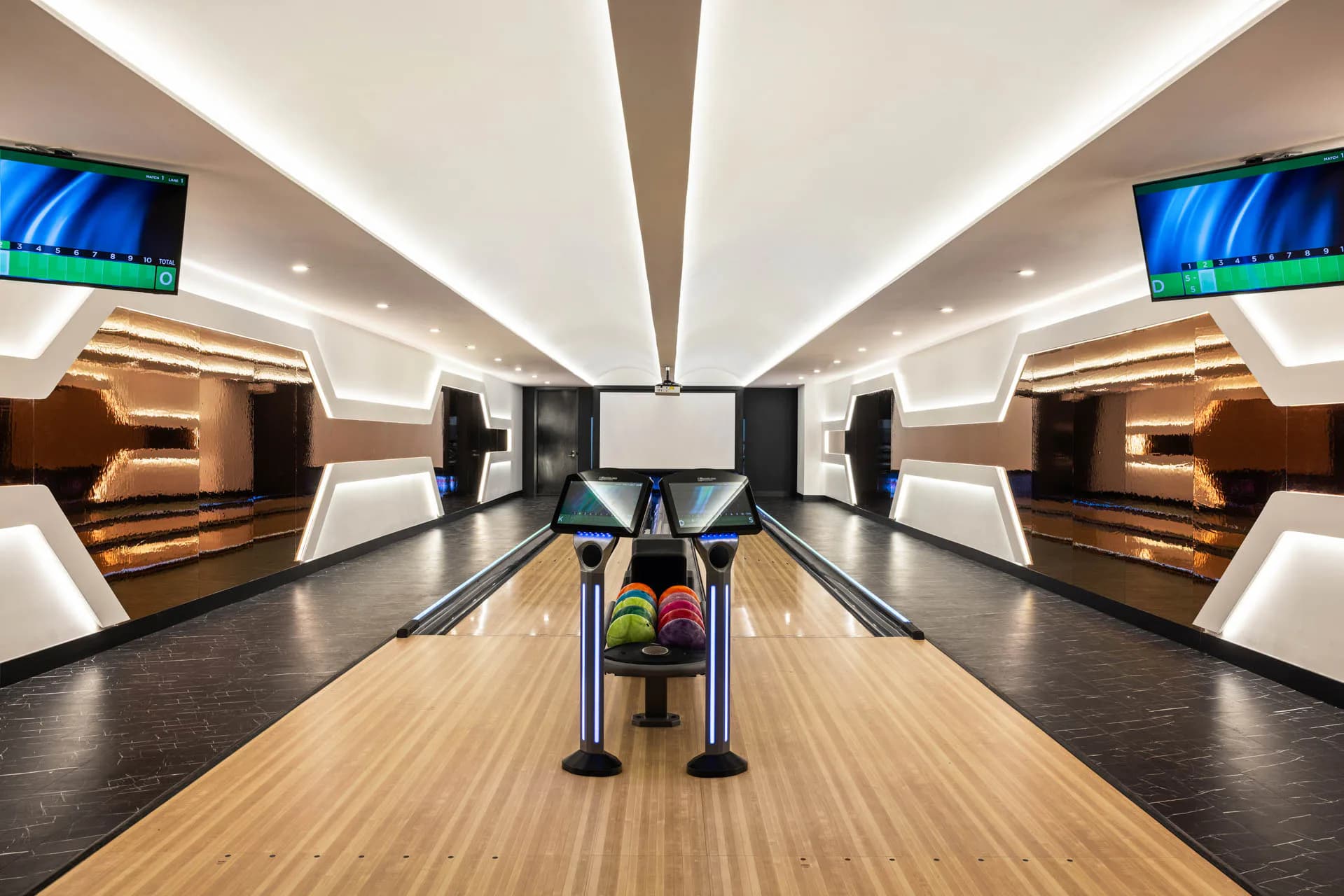 Ultra-modern bowling alley with symmetrical lanes, wooden floors, bronze seating alcoves, blue video screens, and geometric white ceiling with integrated lighting by Tugce Kodalak.