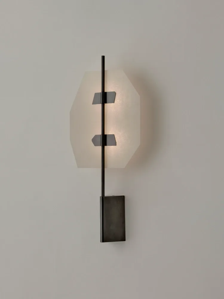 Minimalist sculptural installation featuring a cream-colored organic form pierced by a dark metal rod with geometric elements, mounted on a white wall by Volker Haug.