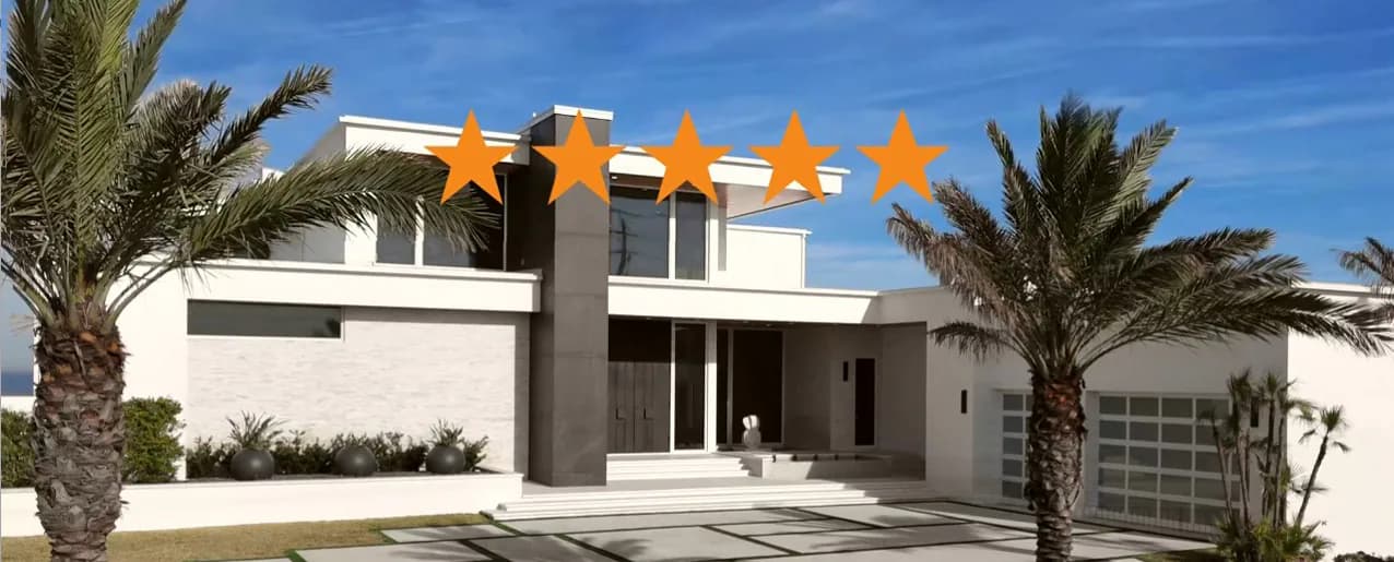 Modern white residential villa with dark horizontal accents, flanked by palm trees, featuring clean geometric lines and contemporary architecture by Yaminah Rosa.
