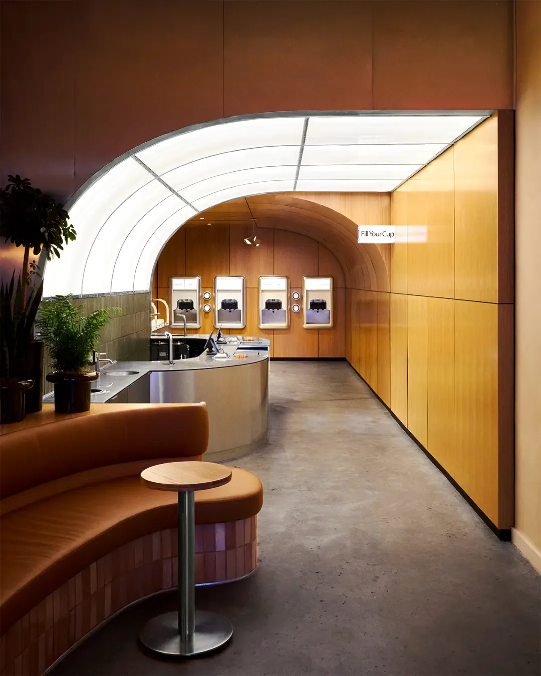 Warm-toned retail interior with curved wooden walls, arched skylight, curved seating area, and display counter by Zhixiao Yu.