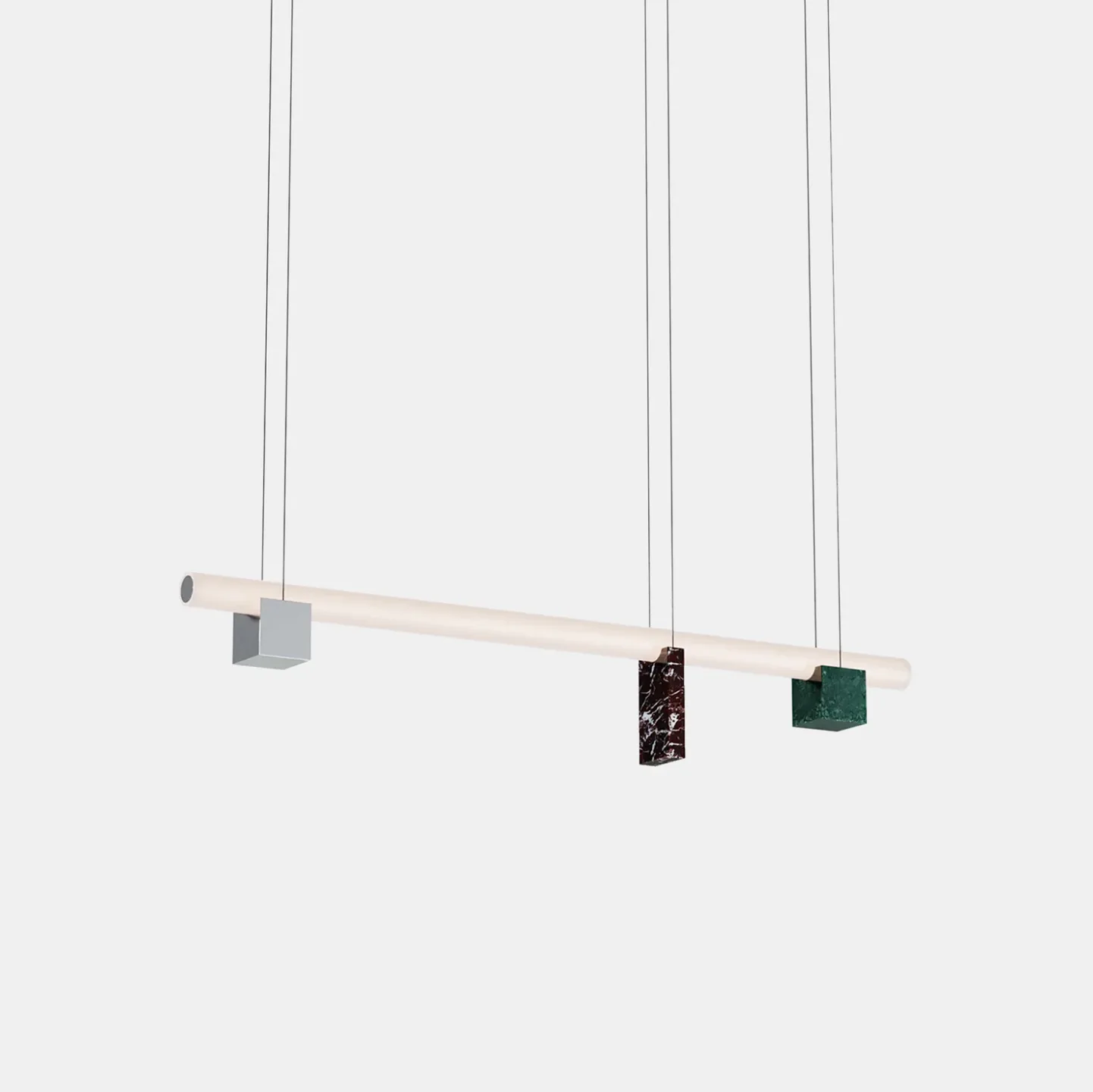 Minimalist pendant light installation featuring a natural wood beam with three hanging geometric fixtures in gray, patterned, and green finishes by Zoë Mowat.