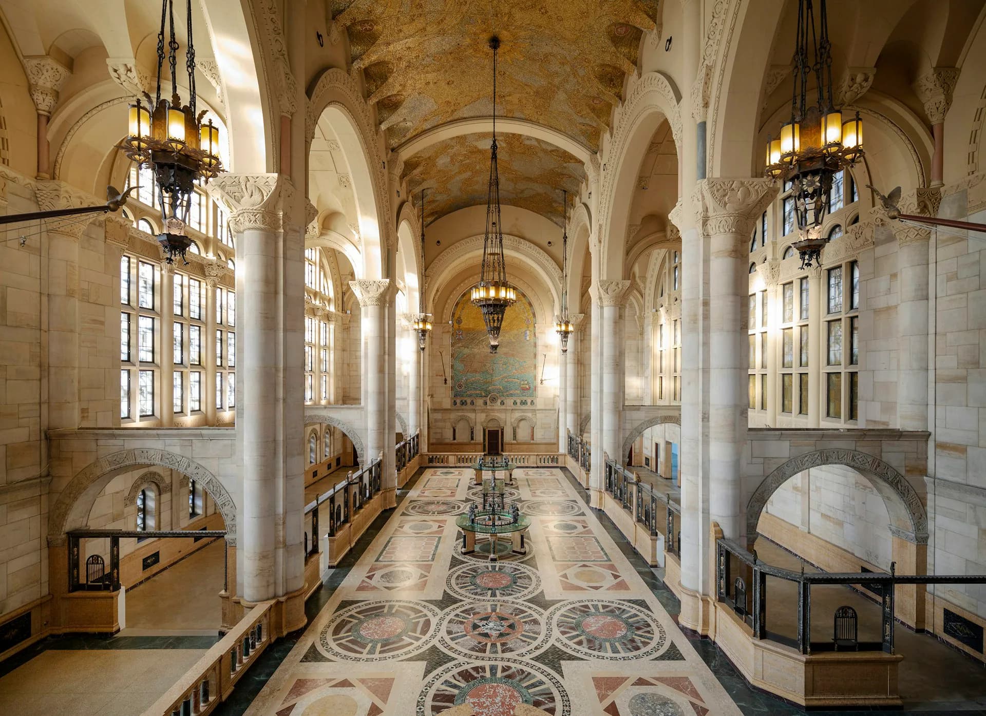 A neoclassical church interior featuring a barrel-vaulted ceiling, ornate decorative floor patterns, white stone columns, and brass fixtures, designed by Acheson Doyle Partners Architects, P.C.