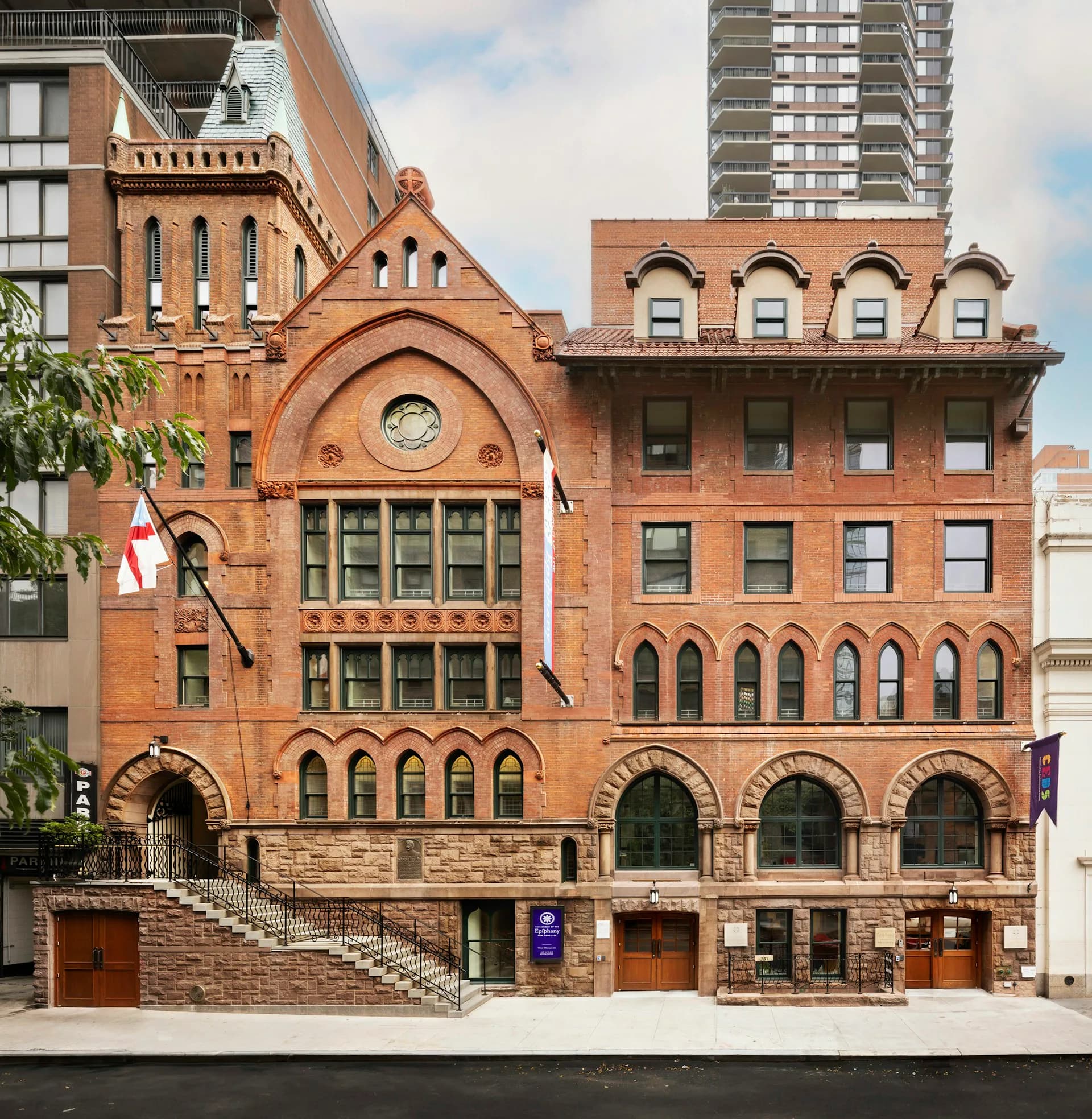 Red brick Victorian-era building facade with Romanesque arches, ornate stonework, and mansard roof detailing, restored by Acheson Doyle Partners Architects, P.C.