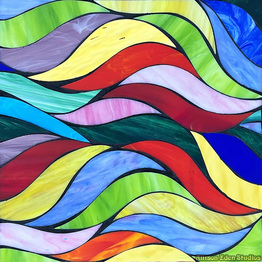 Colorful stained glass window with flowing ribbons of yellow, blue, red, green, and pink separated by black leading, by Allison Eden Studios.