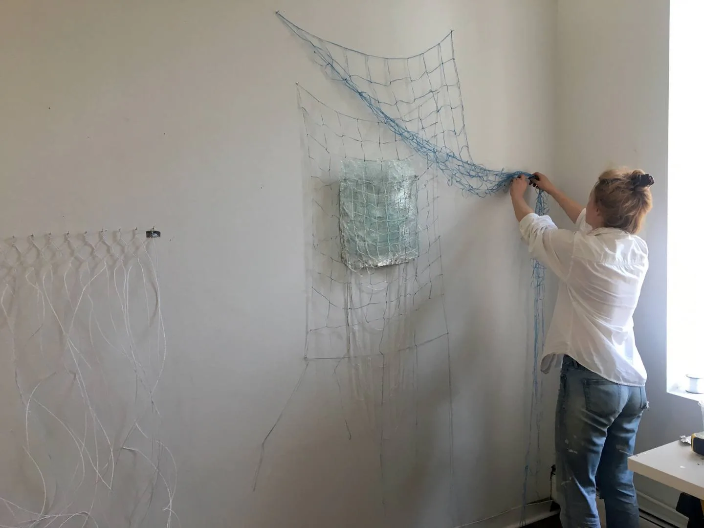 Installation view of an architectural model and wire-frame drawing mounted on a white gallery wall by Alloy Development.