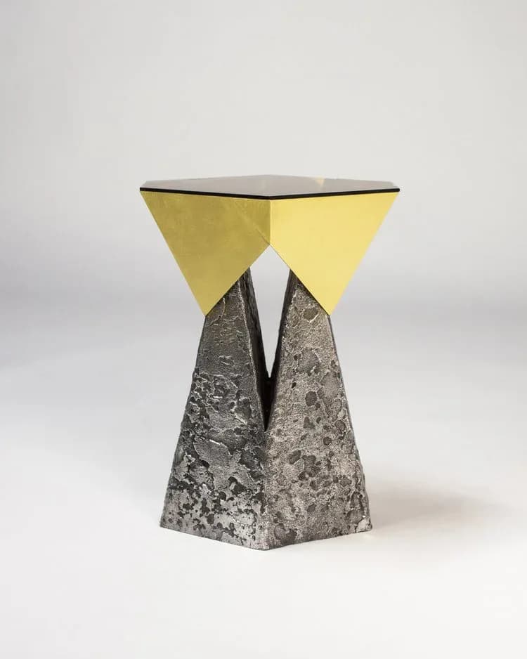 Yellow geometric side table with concrete textured base and black metal top edge, sculptural furniture piece by Arcana.