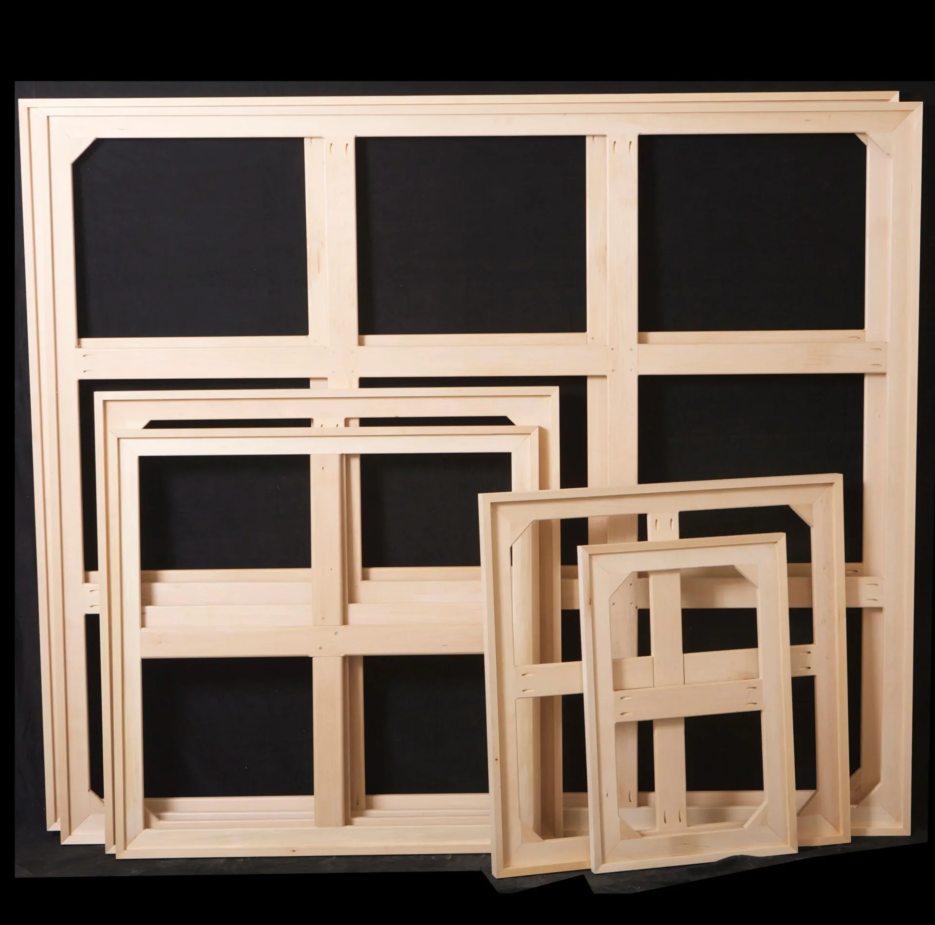 Wooden display shelving units with black backing in varying sizes arranged together, showcasing modular furniture design by Barronarts.