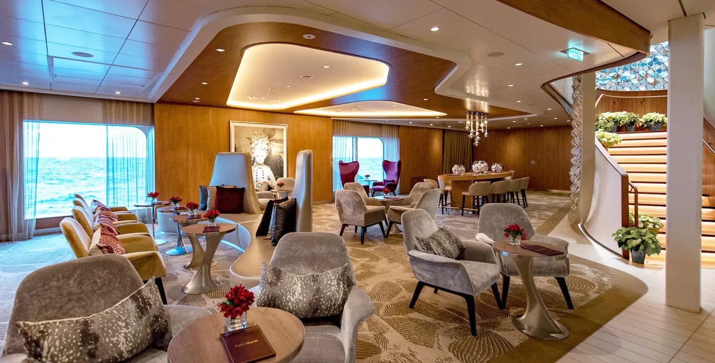 Luxury yacht interior lounge with curved wood ceiling, upholstered seating, ocean views, and contemporary lighting design by BG Studio International Inc.