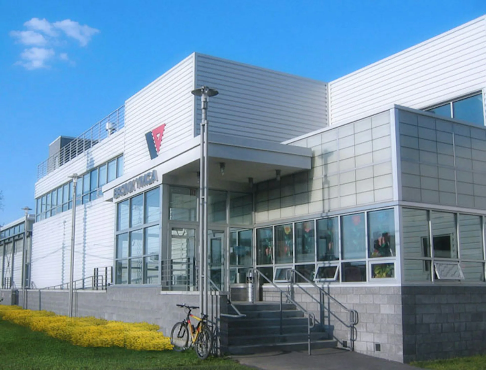 Modern white institutional building with horizontal metal siding, large glazed entrance, and contemporary materials, designed by Blair + Mui Dowd Architects.