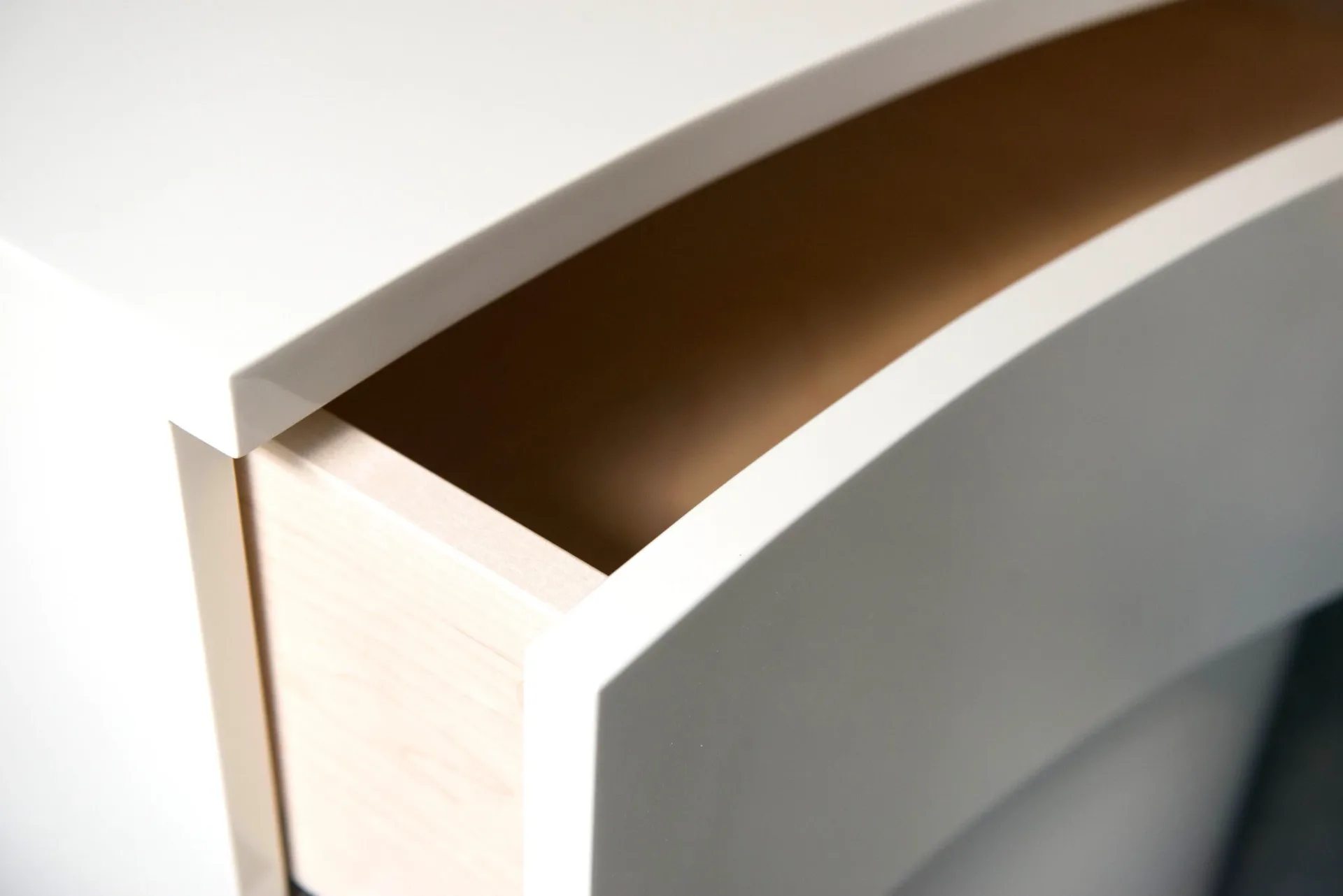 Minimalist white and gray built-in cabinetry with curved architectural detailing and clean lines by Built By Steel.