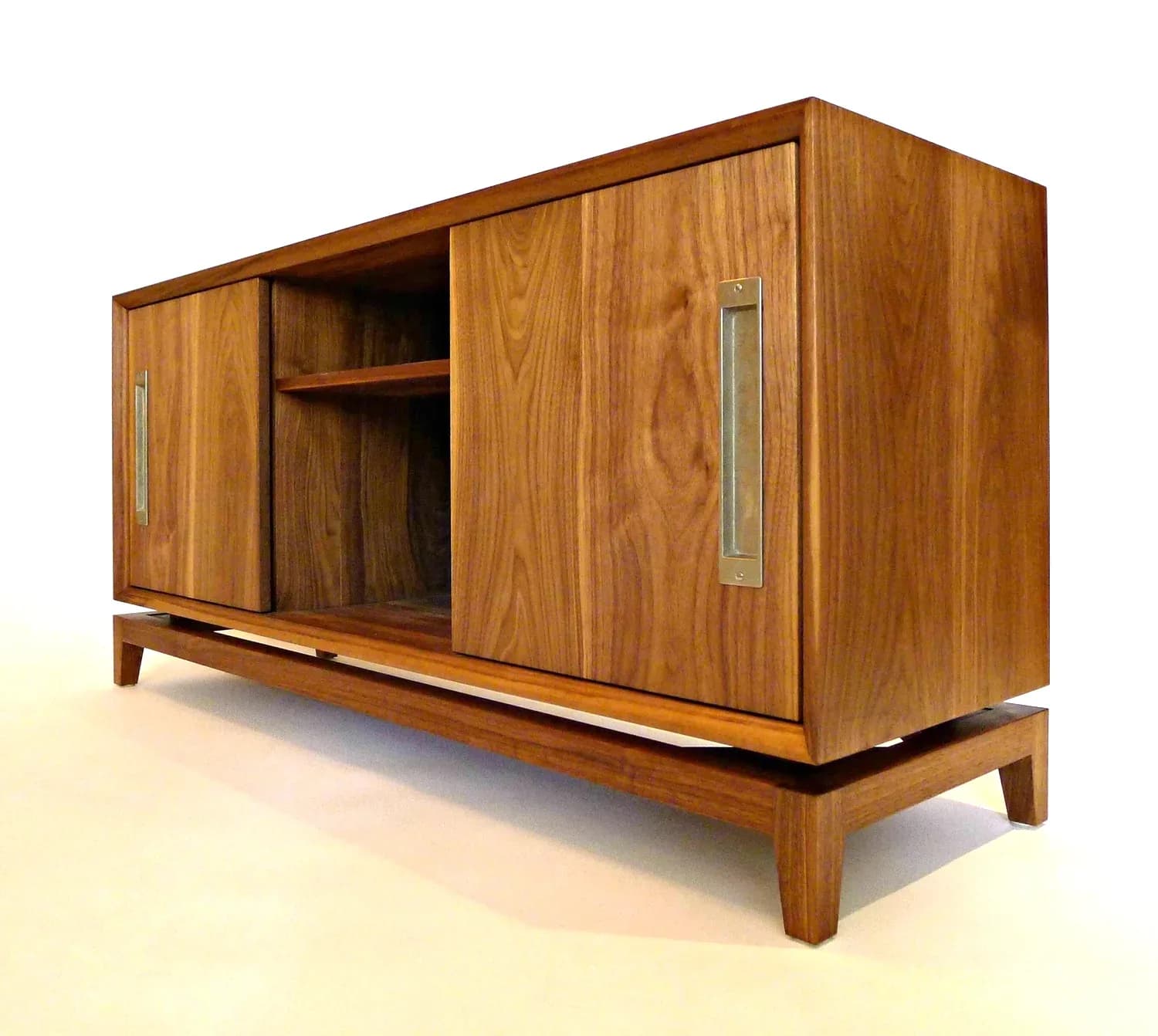 Mid-century modern wooden cabinet with sliding doors and metal handles, rendered with warm walnut tones and soft studio lighting by Built By Steel.