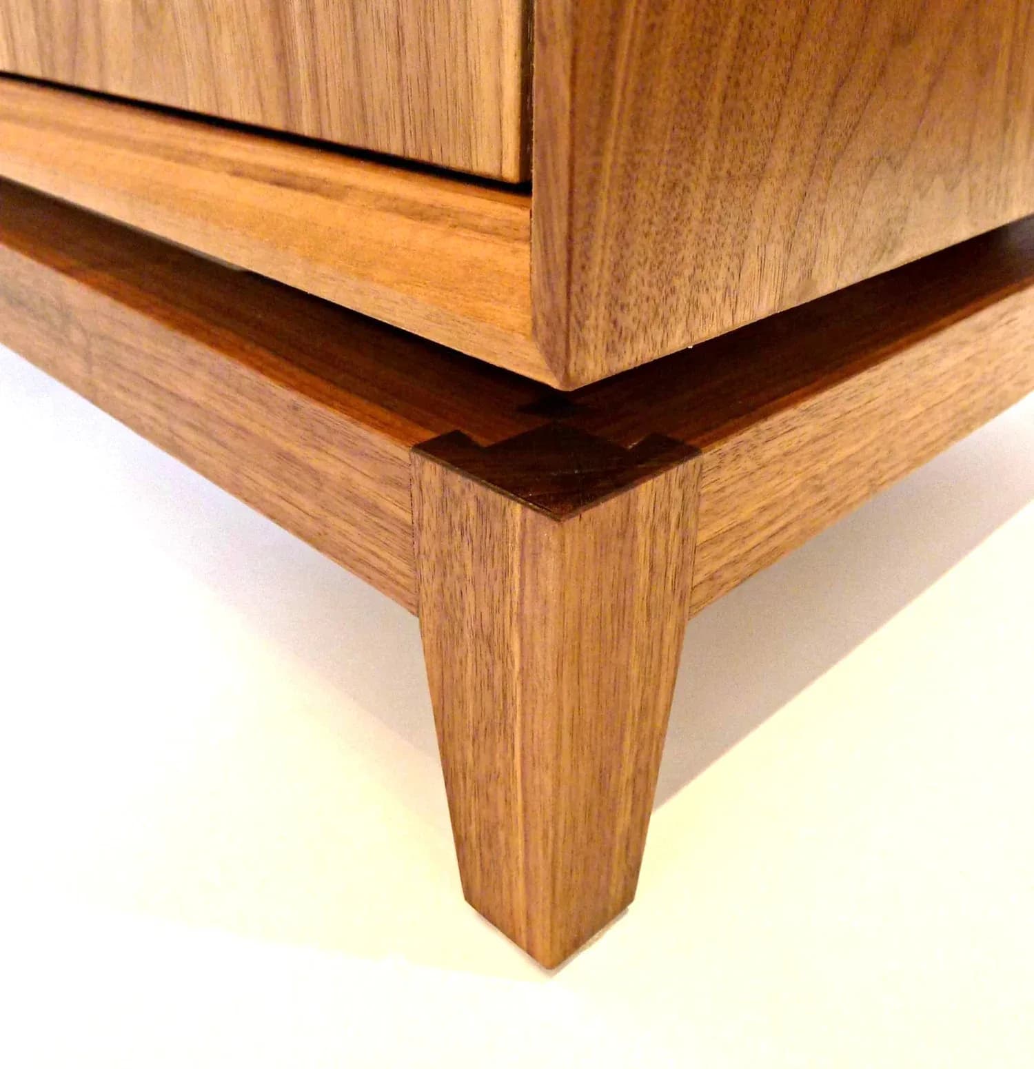 Walnut wood furniture detail showing tapered leg and clean joinery craftsmanship by Built By Steel.