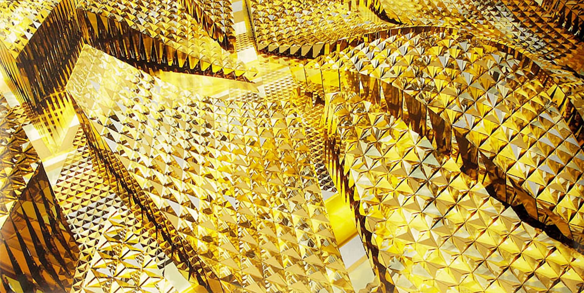 Abstract golden geometric installation with interlocking angular planes and mirrored surfaces creating a complex three-dimensional composition by Bureau V.