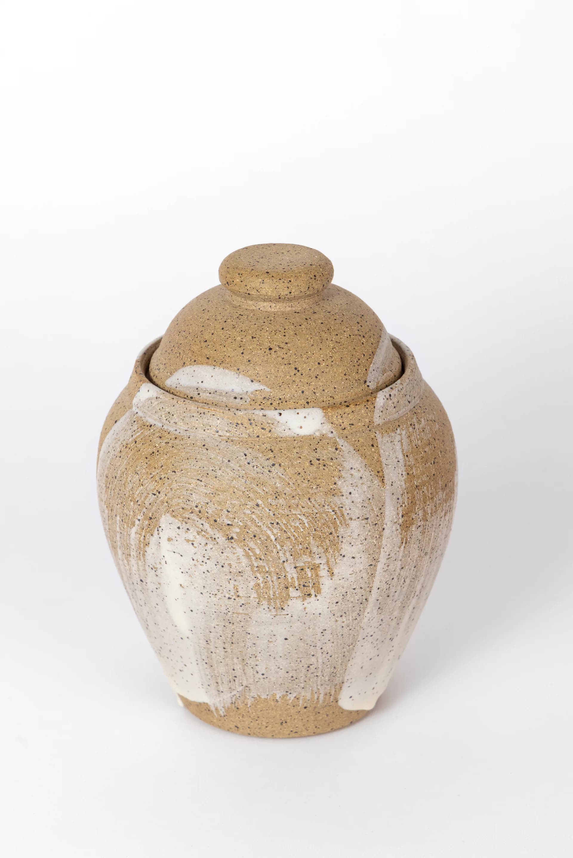 Stoneware covered jar with speckled tan glaze and brushed white accent details, hand-thrown by CAL Ceramics.