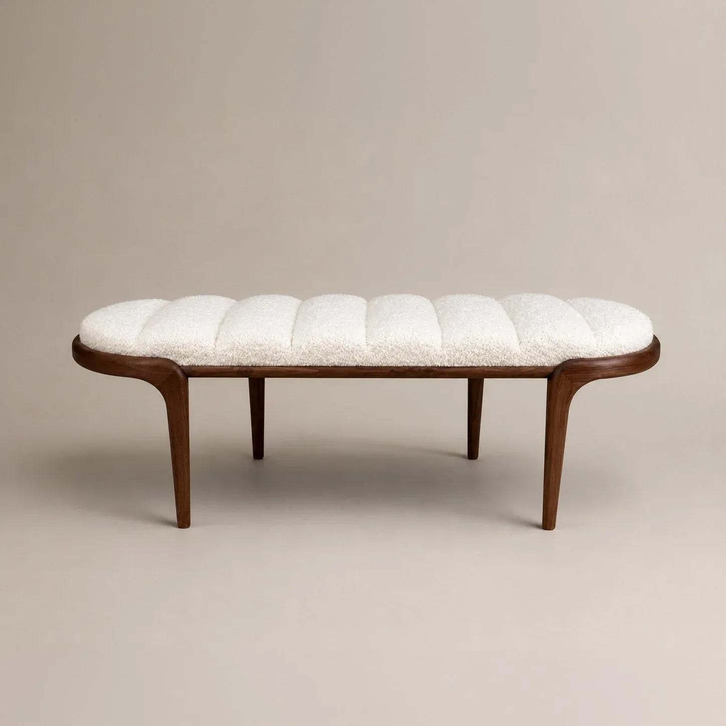 Mid-century modern bench with curved wooden arms, tapered legs, and quilted cream upholstery, rendered by Chapter & Verse.