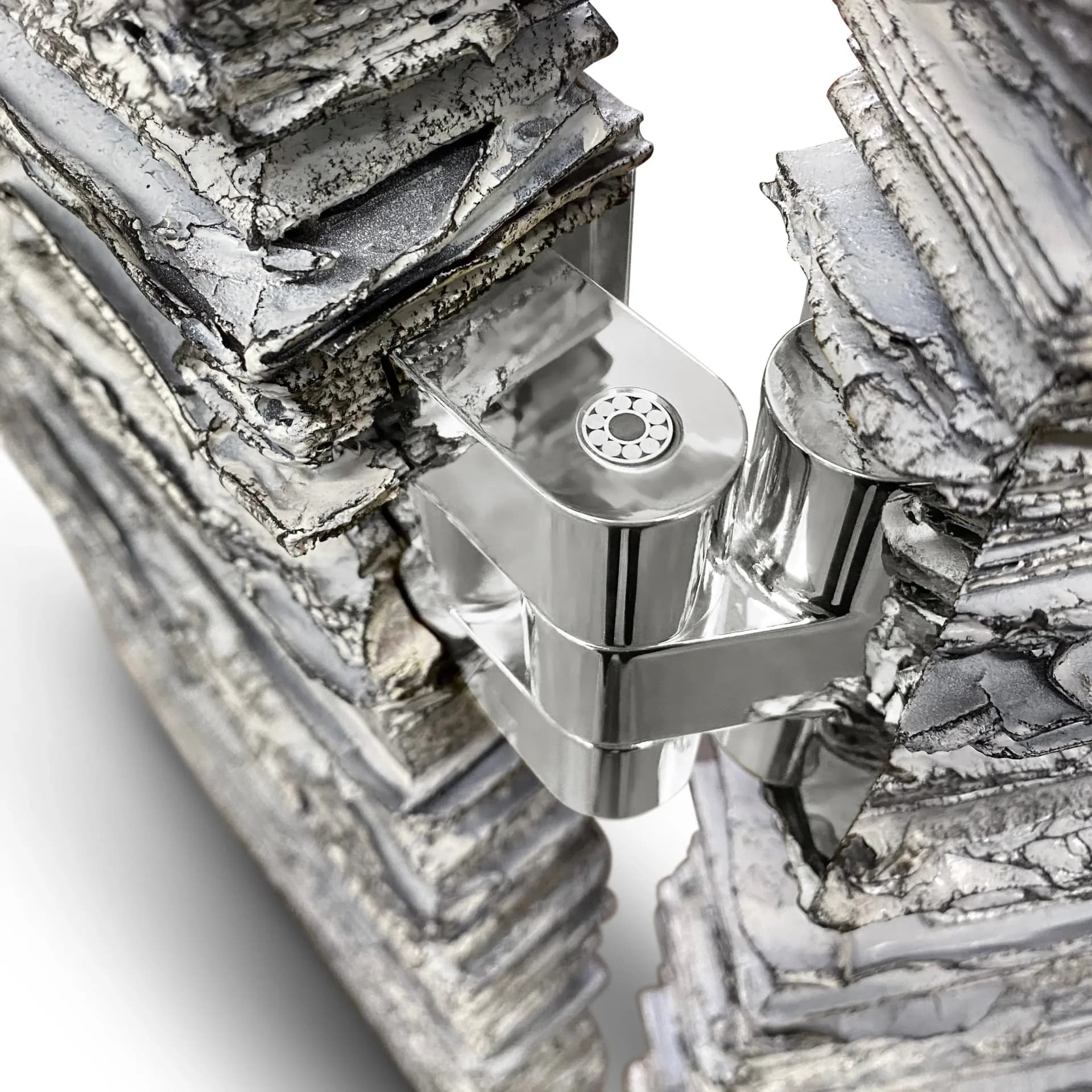 Polished chrome door hardware mounted between birch bark surfaces, demonstrating metallic product design detail by Chapter & Verse.