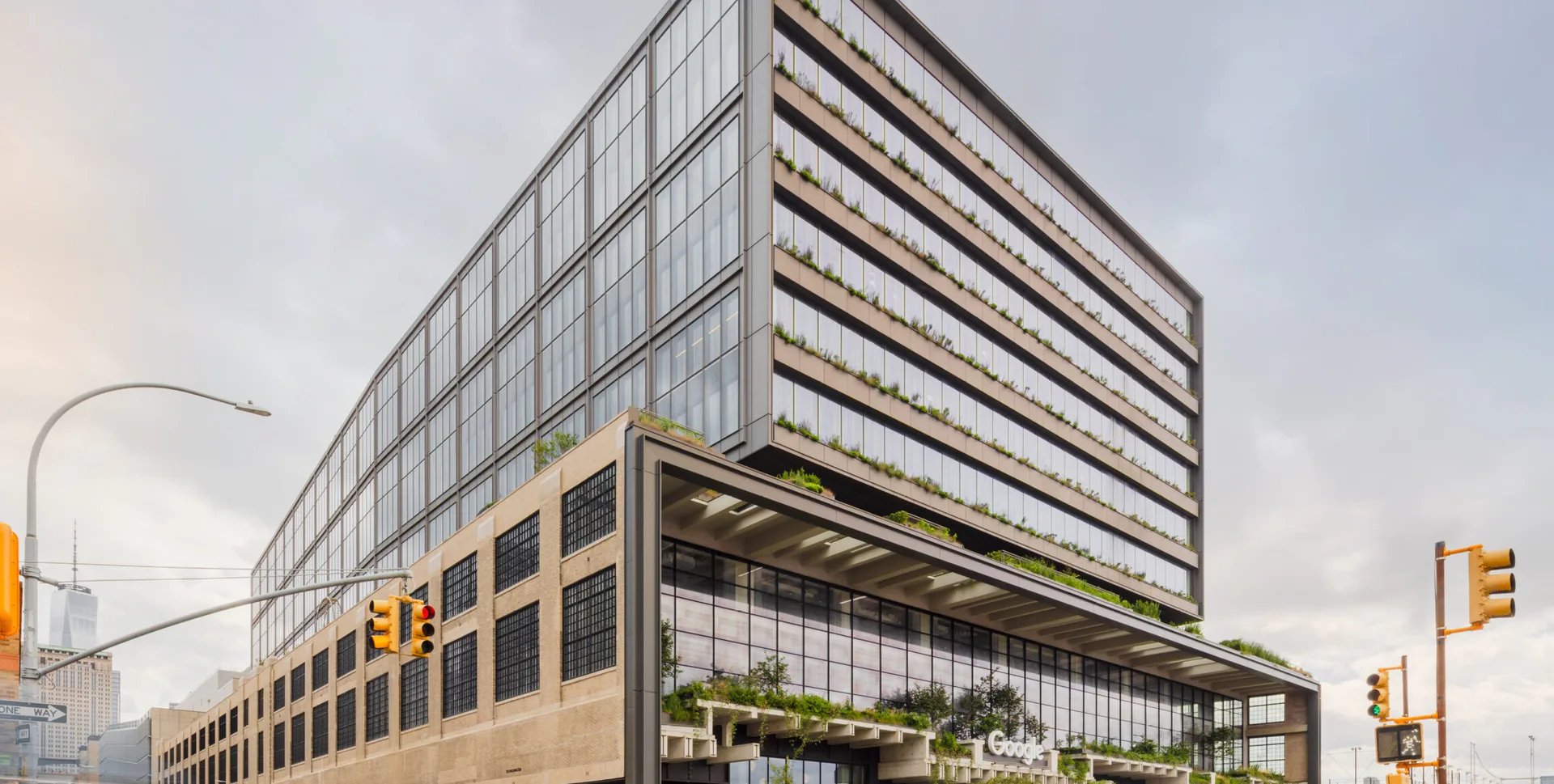 Contemporary mixed-use building with stacked horizontal balconies, warm-toned brick base, and glass upper stories on an urban corner by COOKFOX Architects.