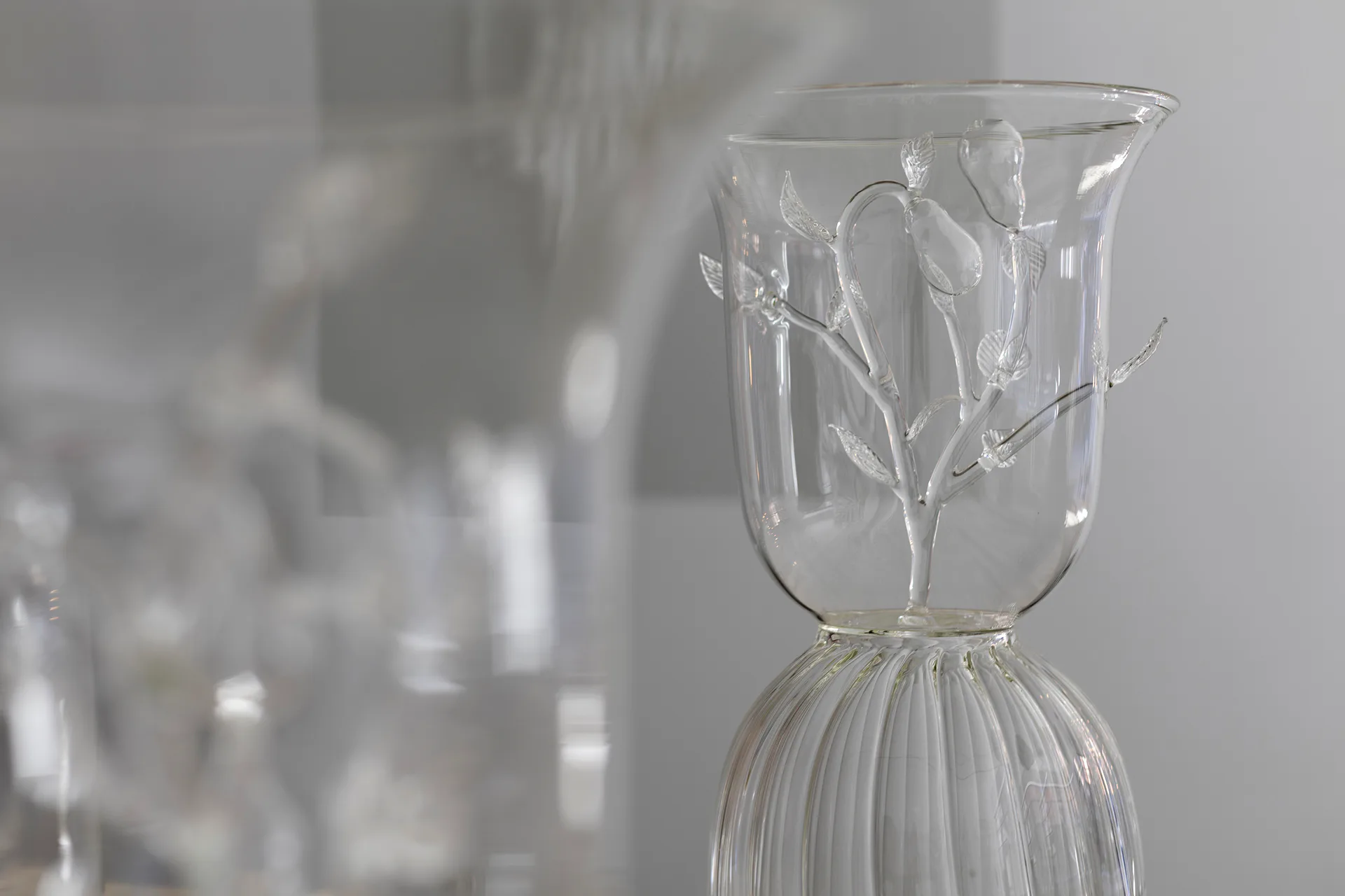 Ethereal glass sculptural vessels with delicate etched botanical motifs and ribbed bases in soft neutral tones by Cristina Grajales Gallery.