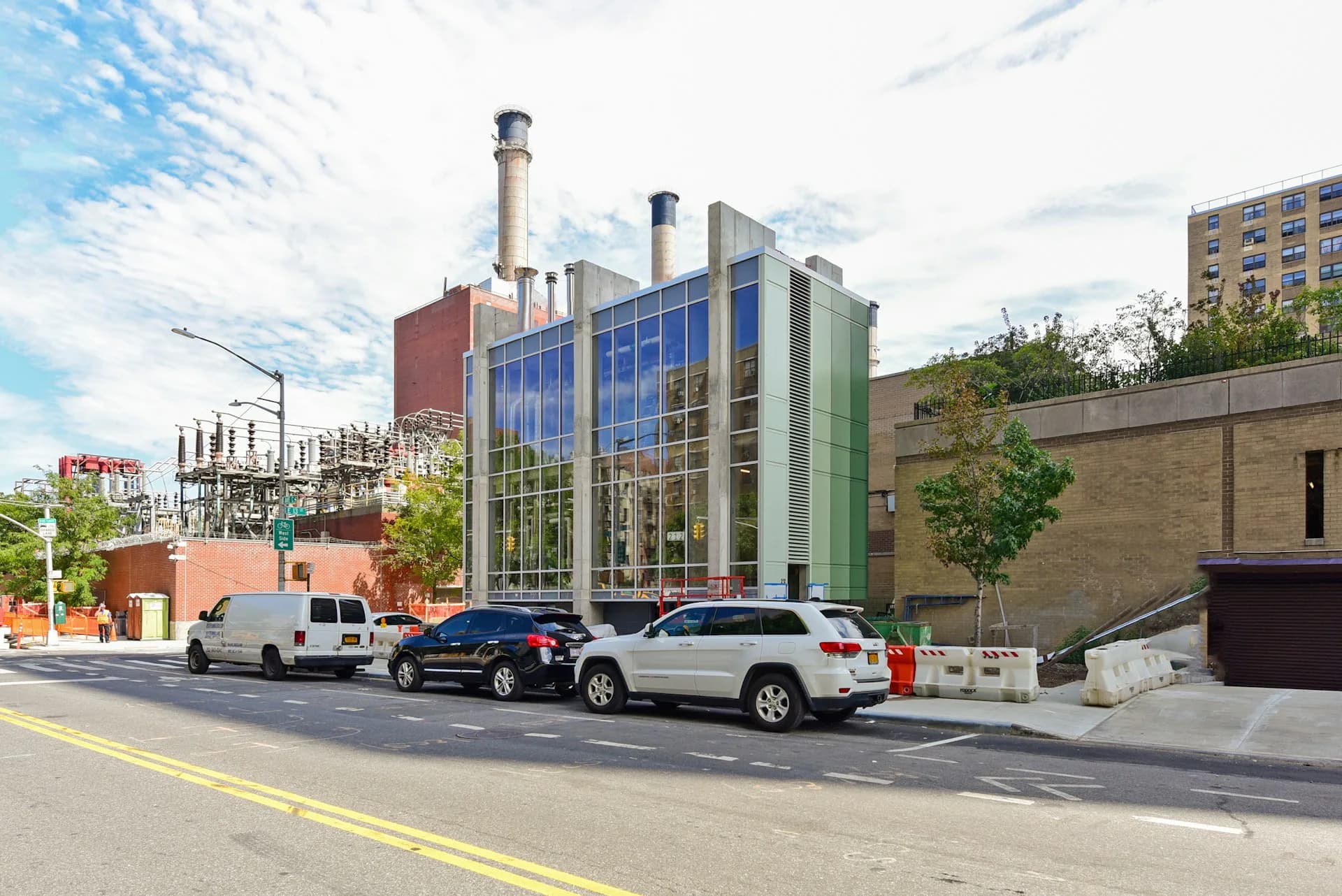 Modern institutional building with blue-glass facade and brick chimney towers on urban street, designed by CTA Architects P.C.