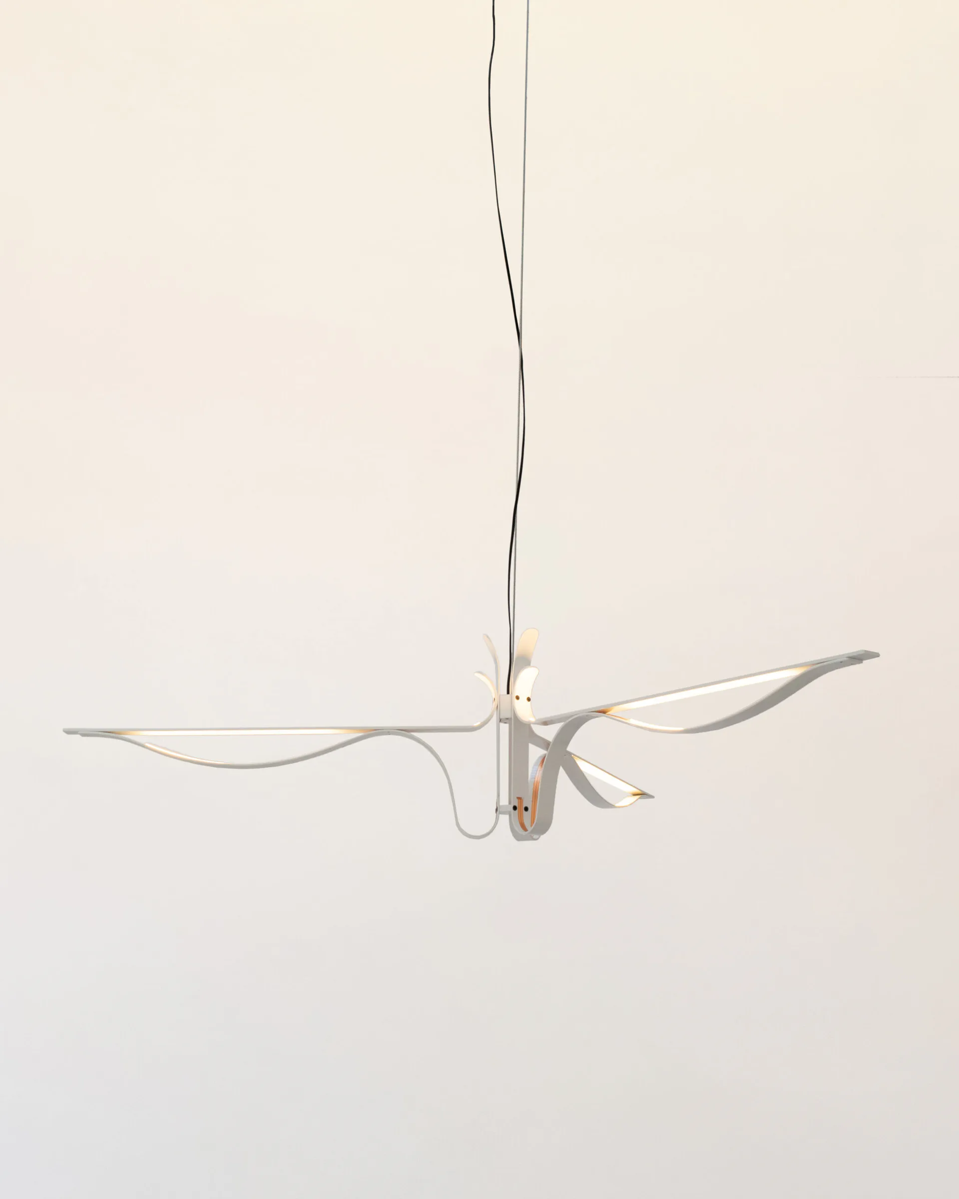 Minimalist pendant light fixture with delicate curved arms and suspended cord, featuring warm metallic tones against neutral backdrop by David Weeks Studio.