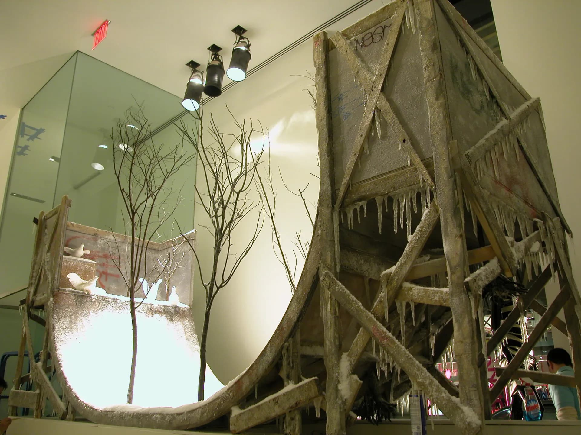 Museum exhibition installation featuring large sculptural tree forms with draped mesh fabric and illuminated glass panels, designed by DCM Fabrication Inc.