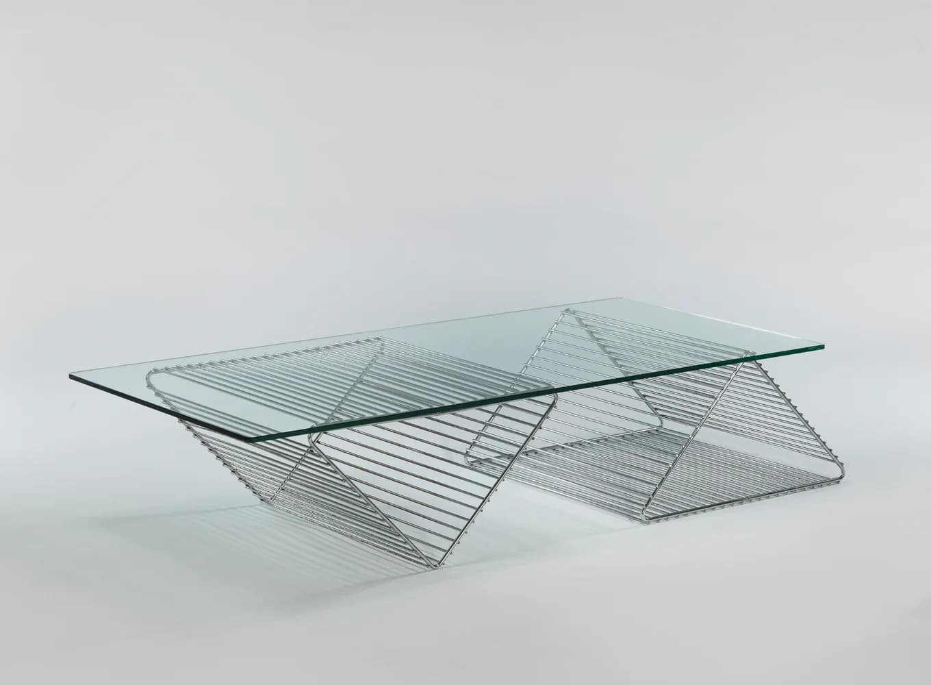 Contemporary glass and metal sculptural table with layered geometric forms and intersecting planes, photographed against a neutral background by Demisch Danant.