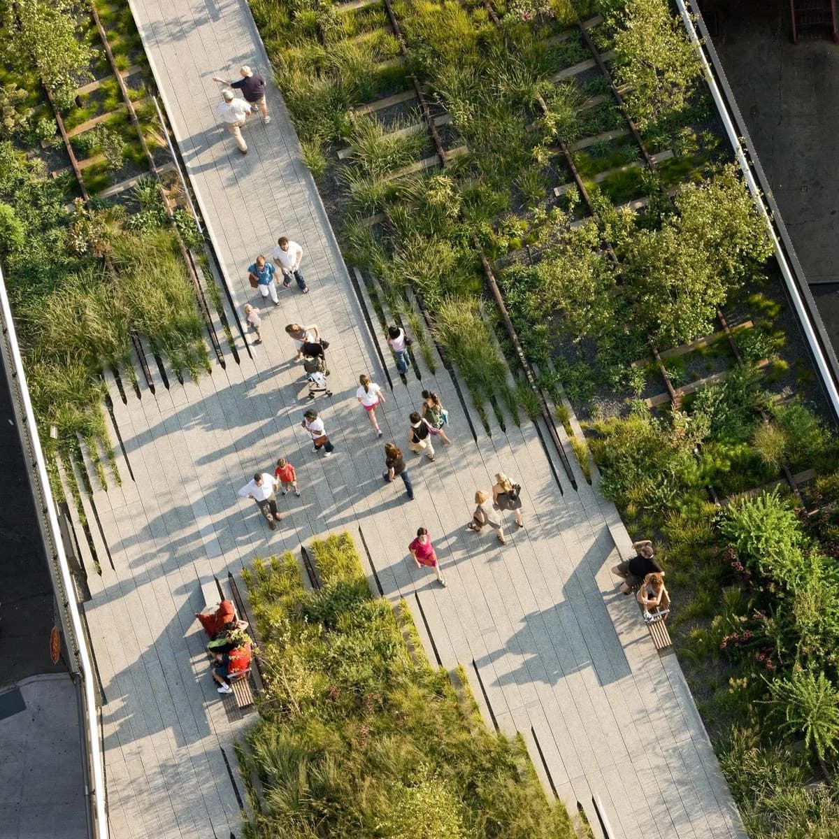 Aerial view of a modern public plaza with paved walkways, integrated seating areas, and lush green vegetation throughout, designed by Diller Scofidio + Renfro.
