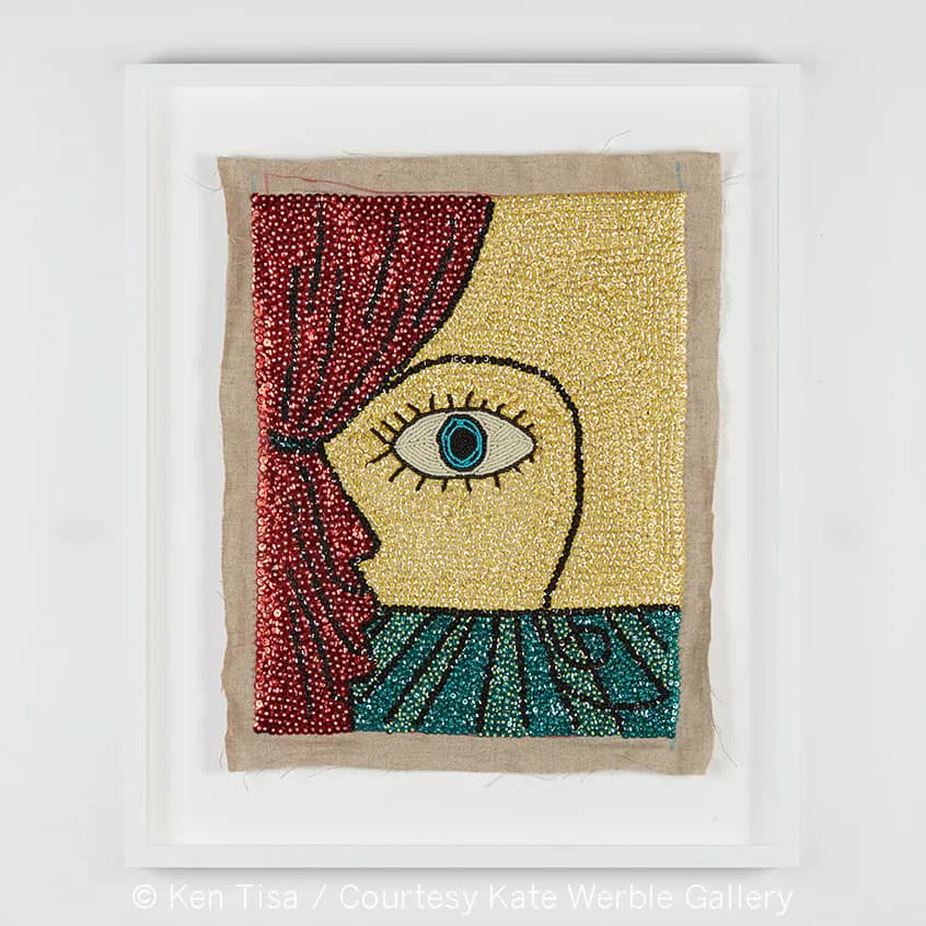 Framed textile artwork featuring a stylized profile with beaded embroidery in red, yellow, and teal on natural linen by Kate Werble Gallery.