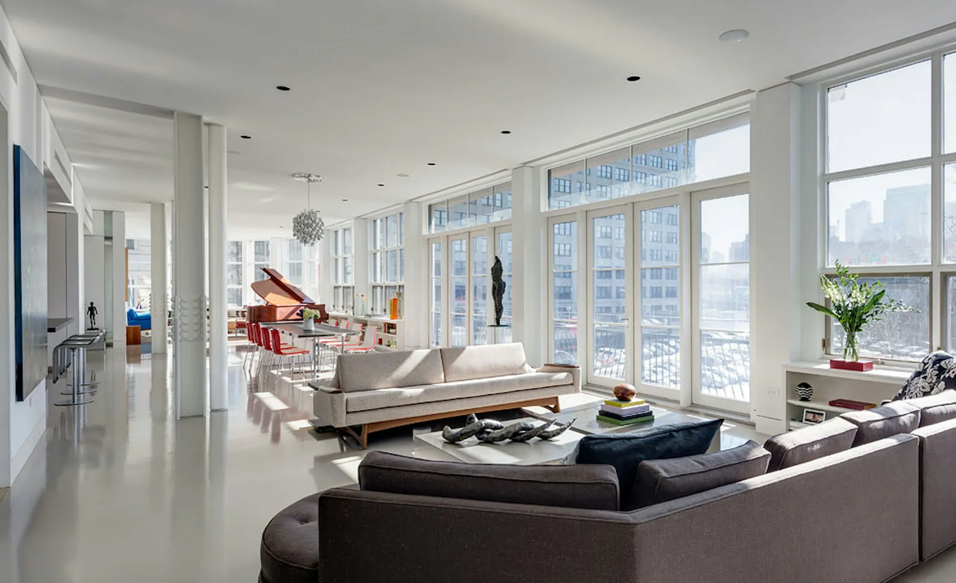 Modern high-rise apartment living room with floor-to-ceiling windows, neutral palette, gray sofa, black accent pieces, and city views, designed by Ed Kopel, Architect, P.C.