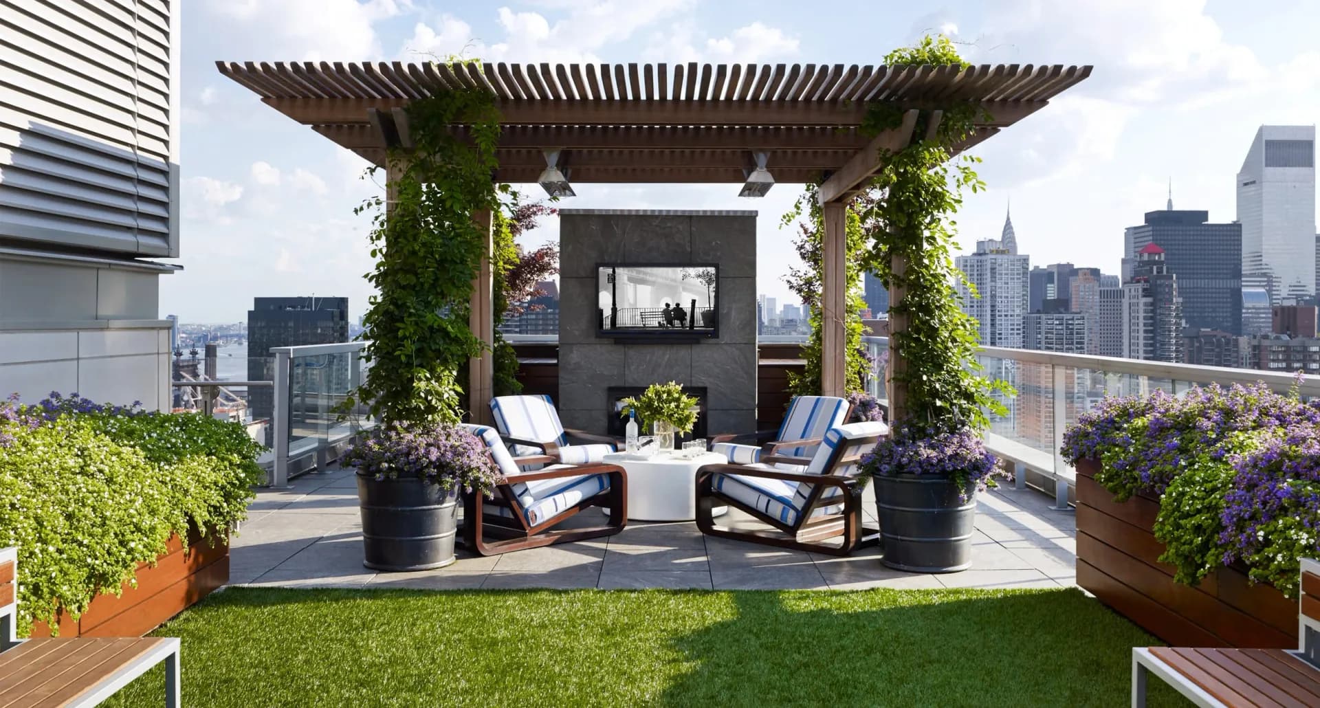 Rooftop terrace with pergola, lounge seating, and artificial turf overlooking Manhattan skyline by Edward Siegel Architect.