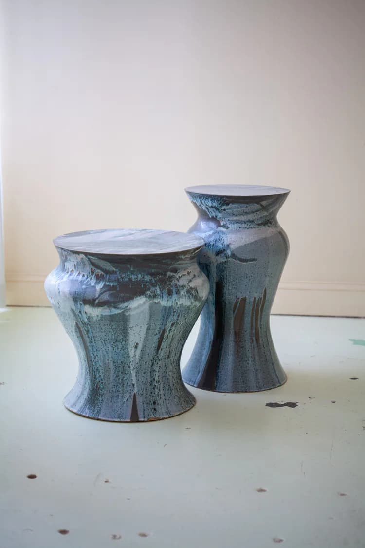 Two ceramic vessels with textured blue-grey glazes and flared rims sit on a white surface, showcasing handcrafted pottery design by Episode.