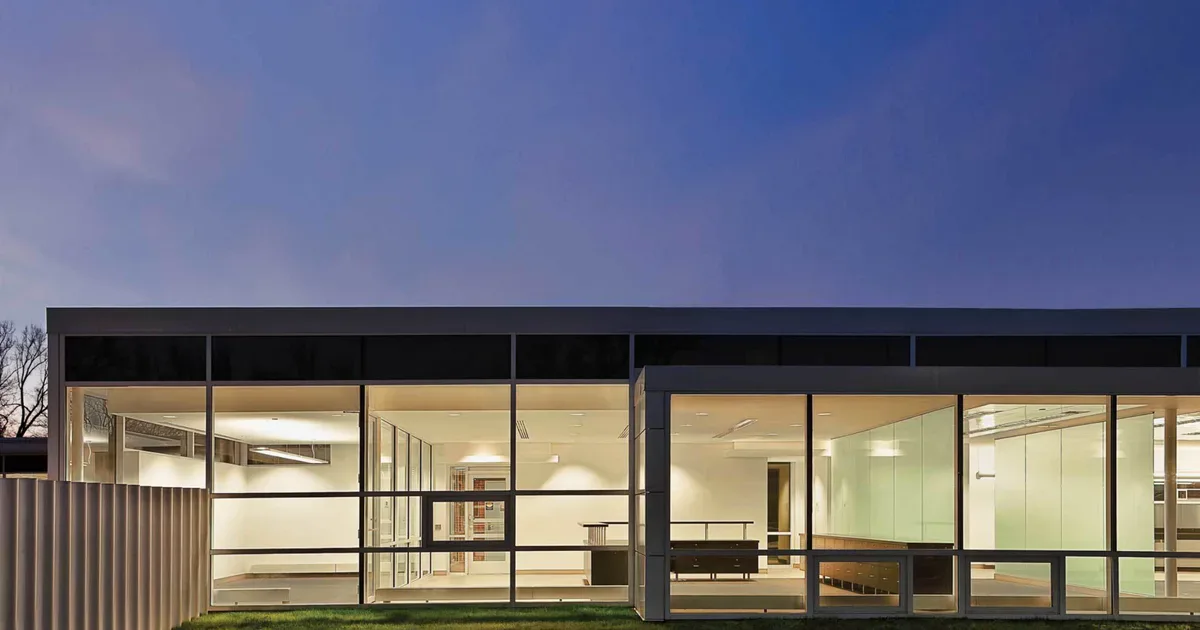 Modern residential interior with floor-to-ceiling glazing, warm wood tones, and minimalist furnishings overlooking an exterior landscape by Epstein Global.