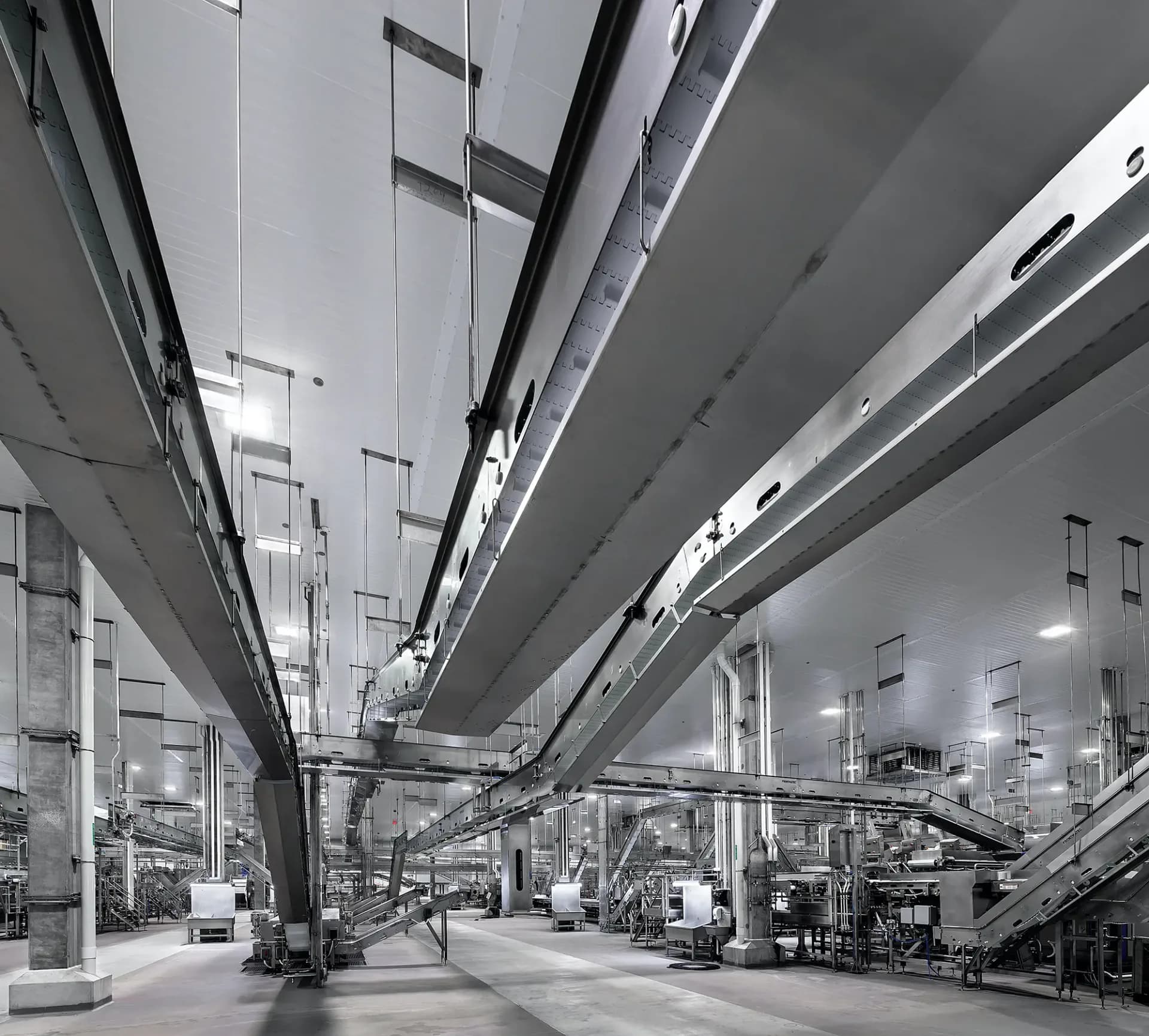 Industrial warehouse interior with exposed structural beams, concrete flooring, and overhead mechanical systems by Epstein Global.