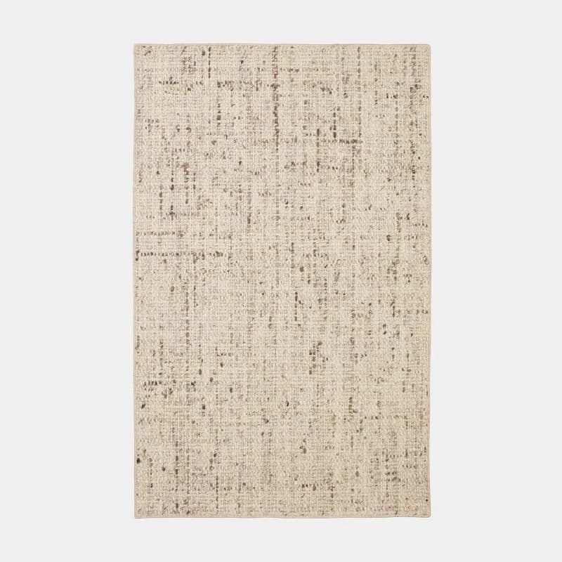 Neutral textured fabric or material sample with woven pattern in beige and cream tones, showcasing surface detail and weave structure by Ernesta.