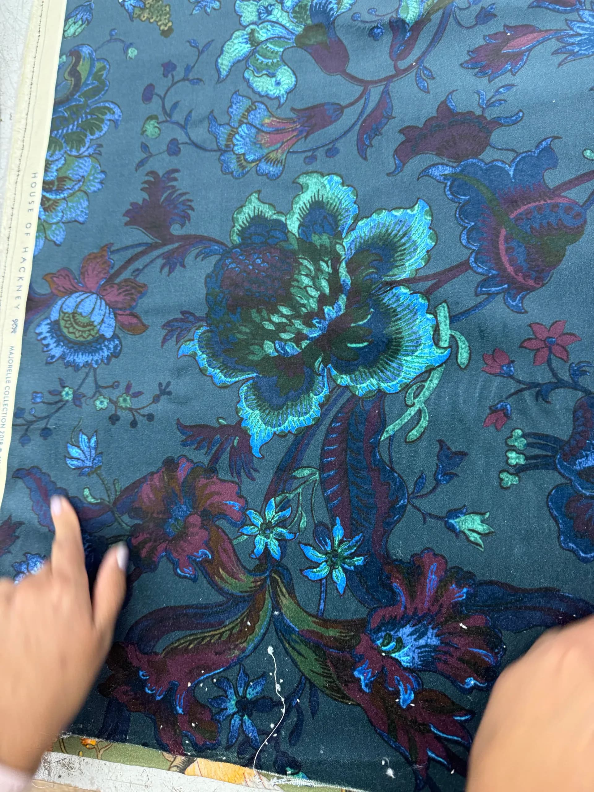 Richly patterned upholstery fabric featuring turquoise and burgundy floral motifs on a charcoal ground, showcasing detailed embroidery work by Find the Thread Upholstery.
