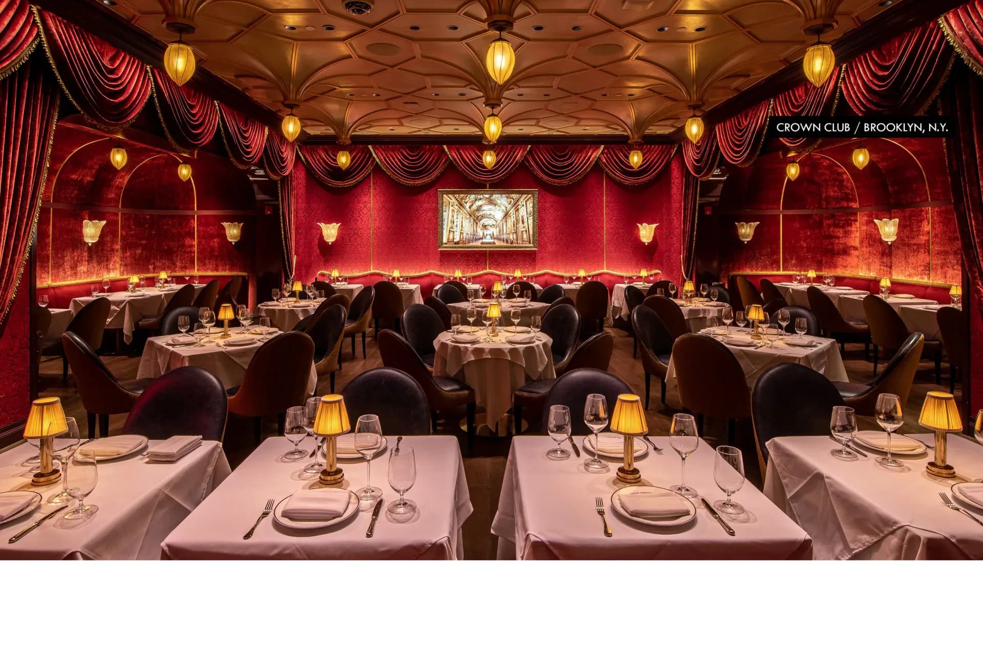 Luxurious red dining room with draped fabric walls, brass pendant lighting, and elegant table settings designed by Focus Lighting.