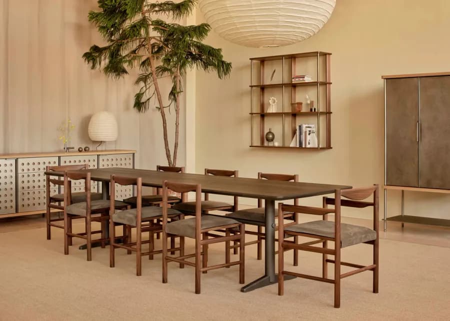 Warm-toned dining space with wooden furniture, potted plant, and floating shelving by Fort Standard, rendered with soft synthetic lighting and idealized material finishes.