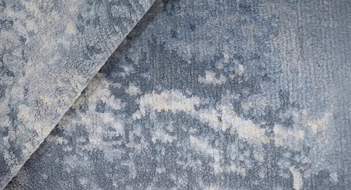 Close-up detail of textured concrete or stone surface with weathered patina and abstract markings in gray tones by Fort Street Studio.