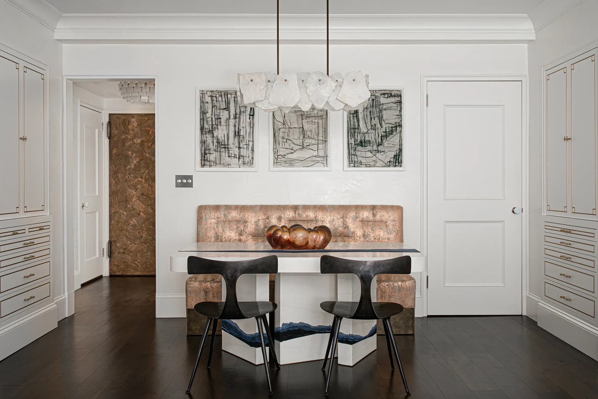 Modern dining room with dark floors, white millwork, mid-century chairs, decorative artwork, and pendant lighting by Fresco Decorative Arts.