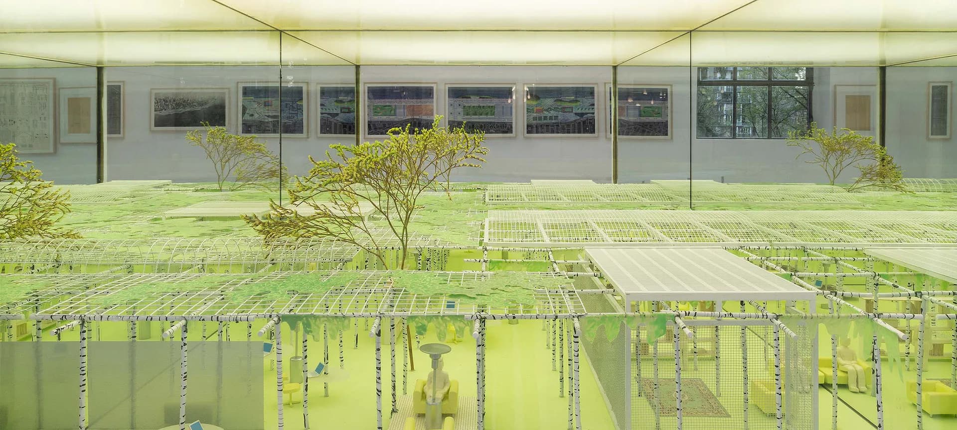 Architectural rendering of a modernist pavilion with floor-to-ceiling glazing, featuring an overhead view of a linear garden installation with suspended green elements by Friedman Benda.