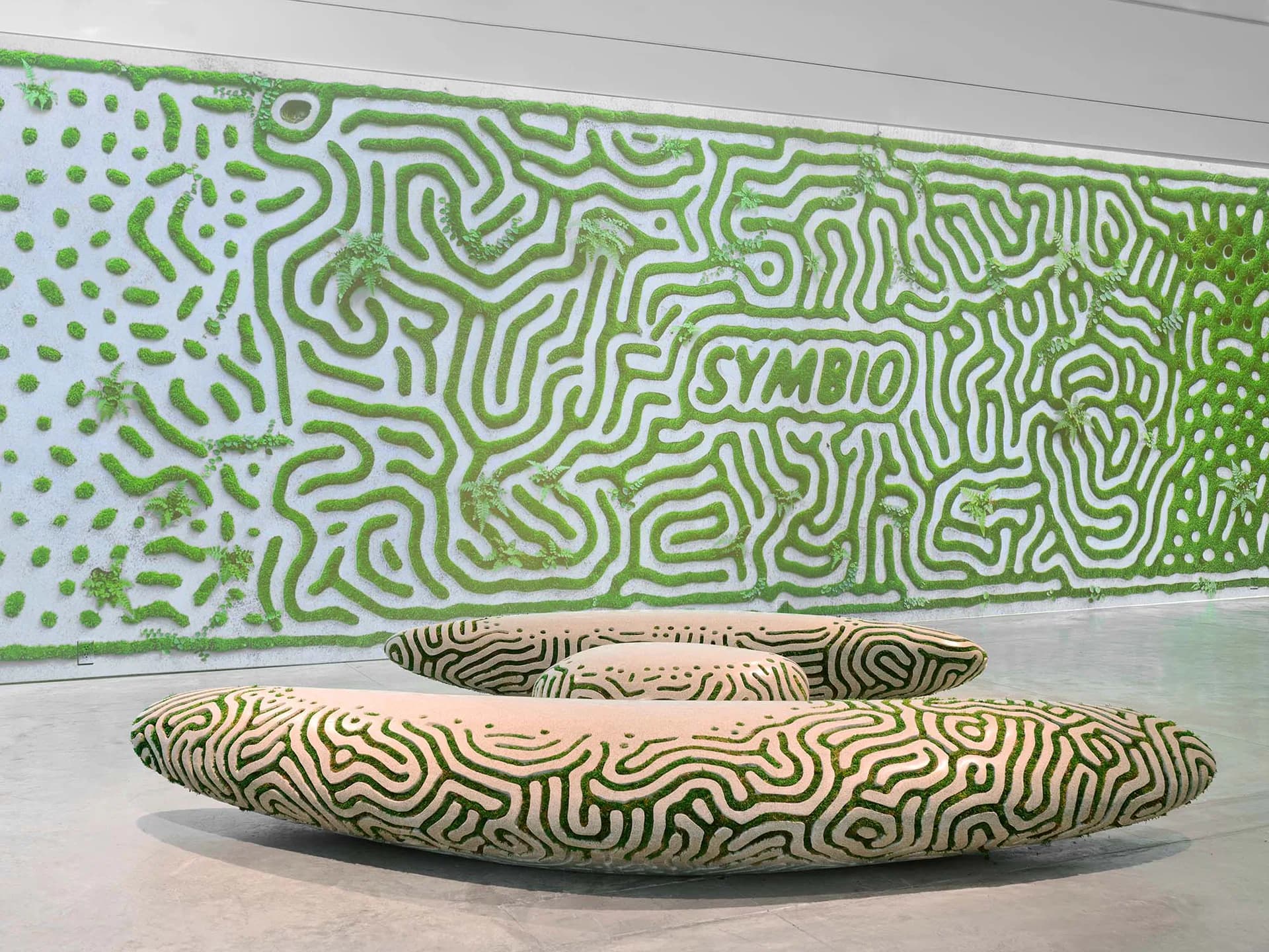 Installation view of undulating green and cream patterned wall and floor sculpture with organic maze-like motifs by Friedman Benda.