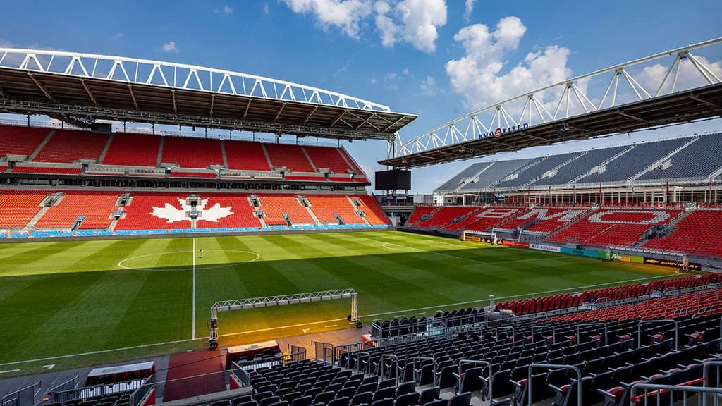 Anfield Stadium's red seating bowl with green pitch and white structural trusses, designed by Gensler New York.
