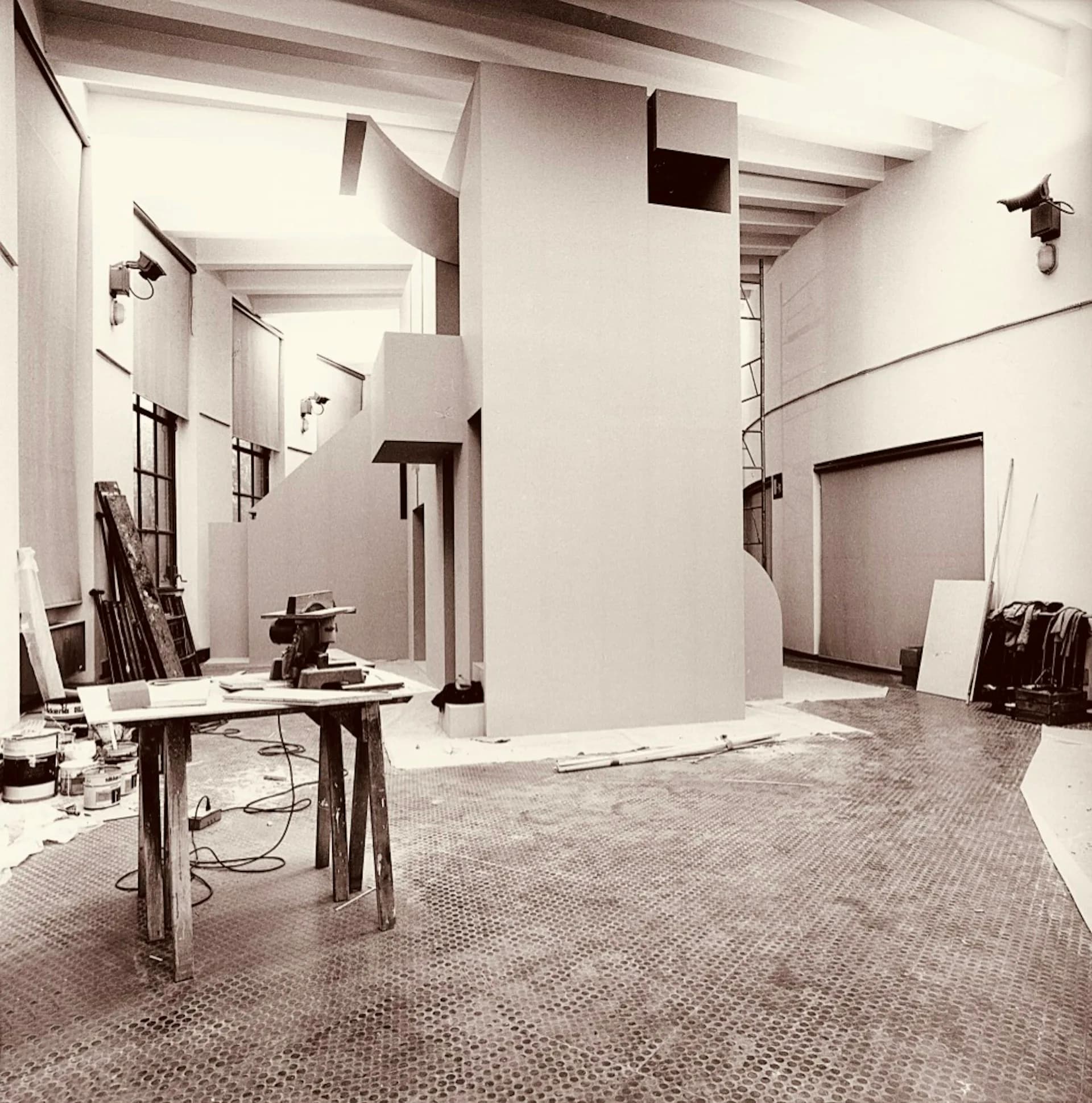 Minimalist studio interior with white walls, exposed beam ceiling, concrete flooring, and sculptural architectural elements by George Ranalli Architect FAIA.