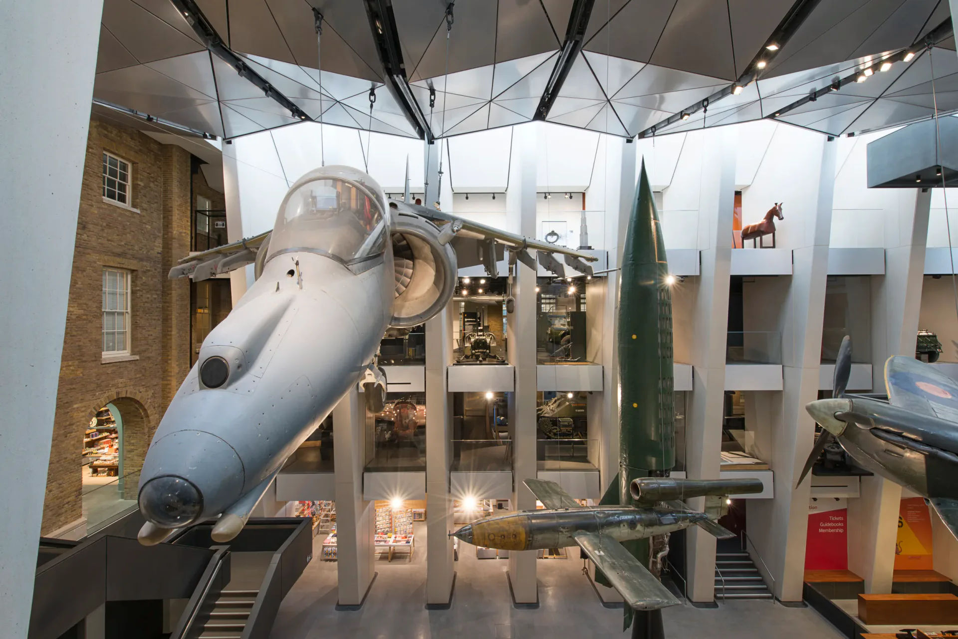 Museum exhibition interior with dramatic architectural elements including a large sculptural slide, display cases, and curved ceiling structures by George Sexton Associates.
