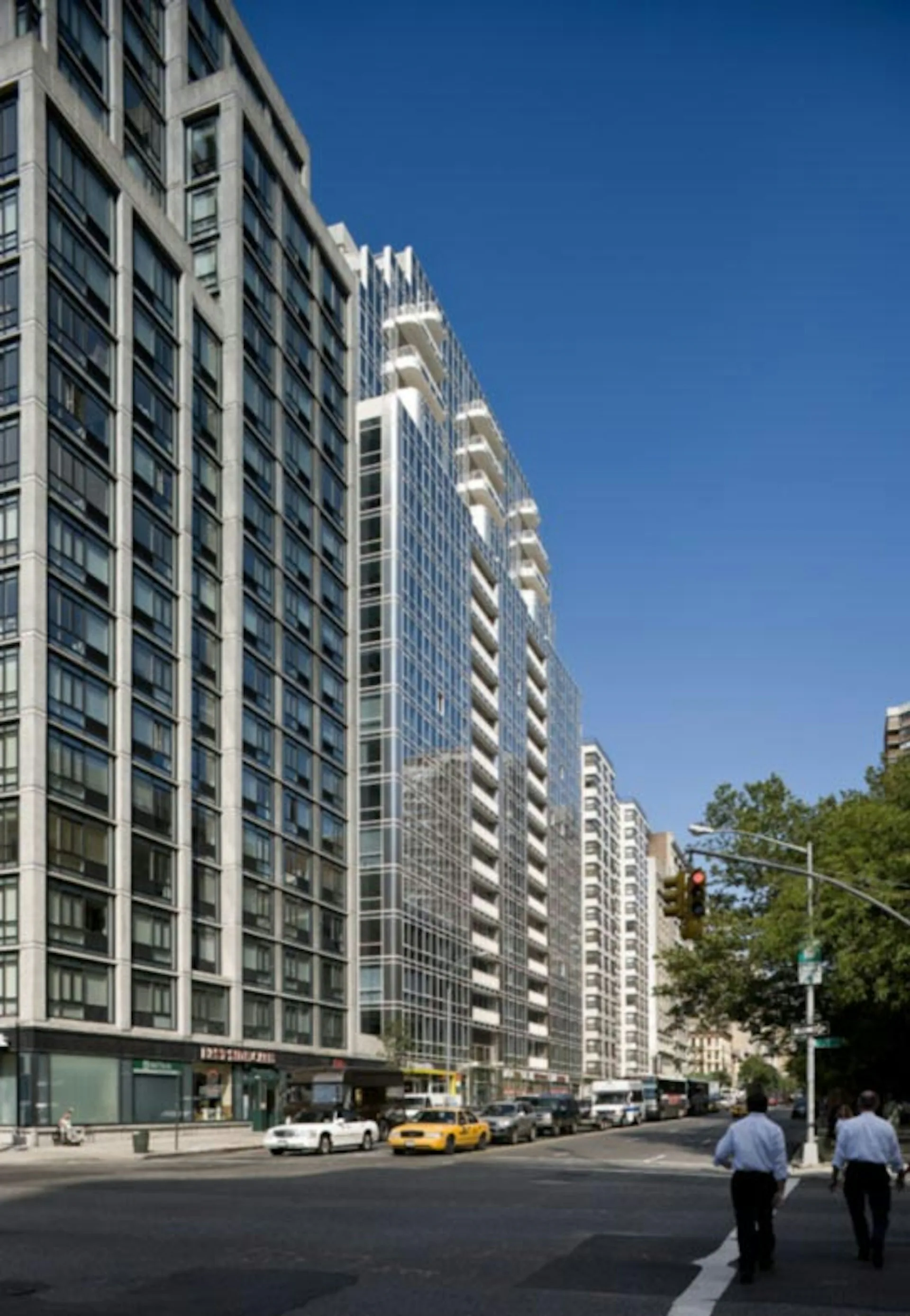 Street-level view of modern residential high-rise buildings with regular window patterns and ground-floor retail, designed by Gerner Kronick + Valcarcel, Architects, DPC.