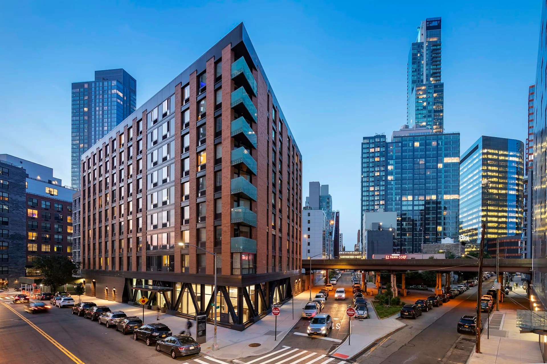 A contemporary mixed-use building with brick and glass facade featuring ground-floor retail and residential units above, designed by GF55 Architects in an urban setting.